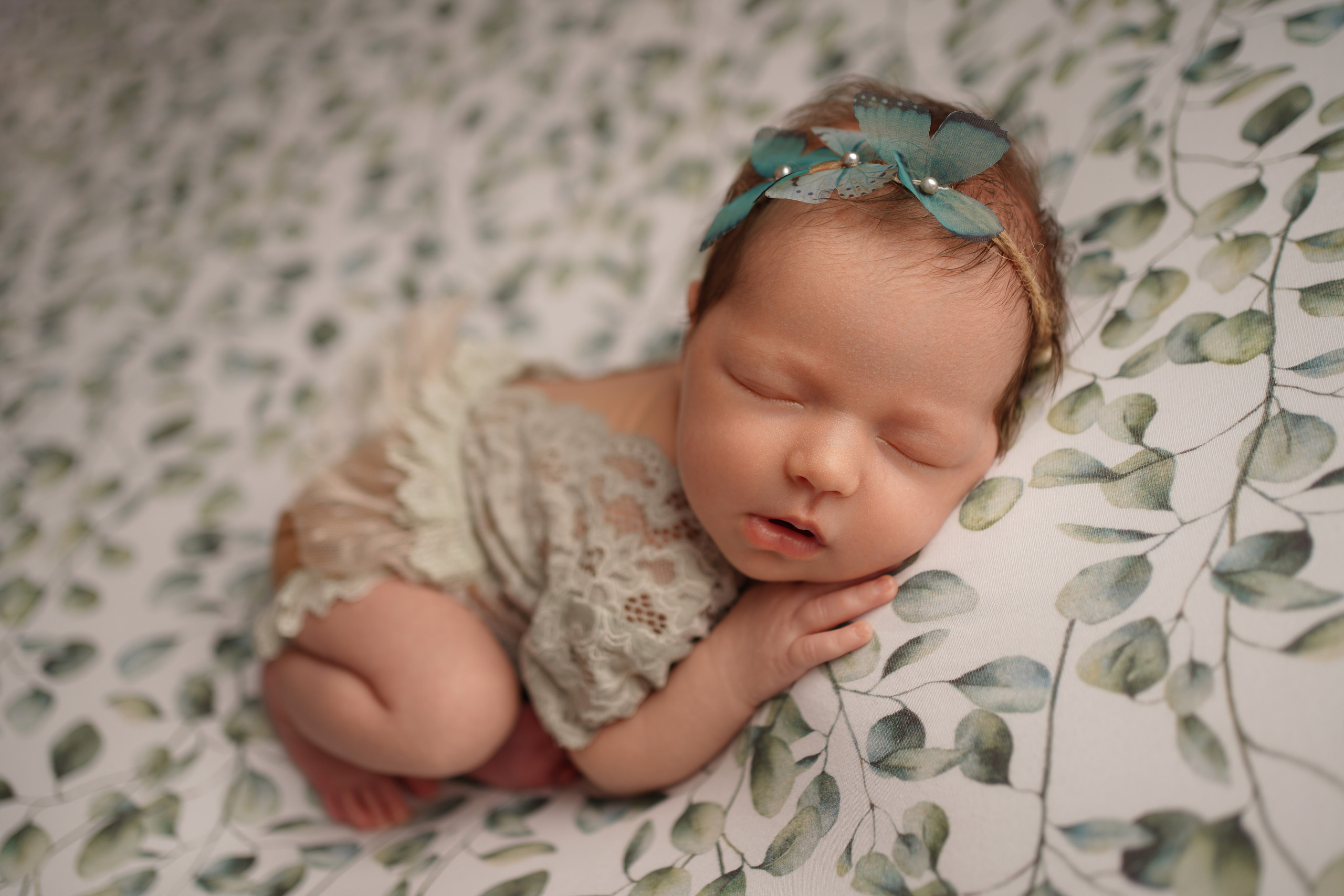 Stilvolle Babymode: Neugeborenes in einzigartiger Kugel-Position