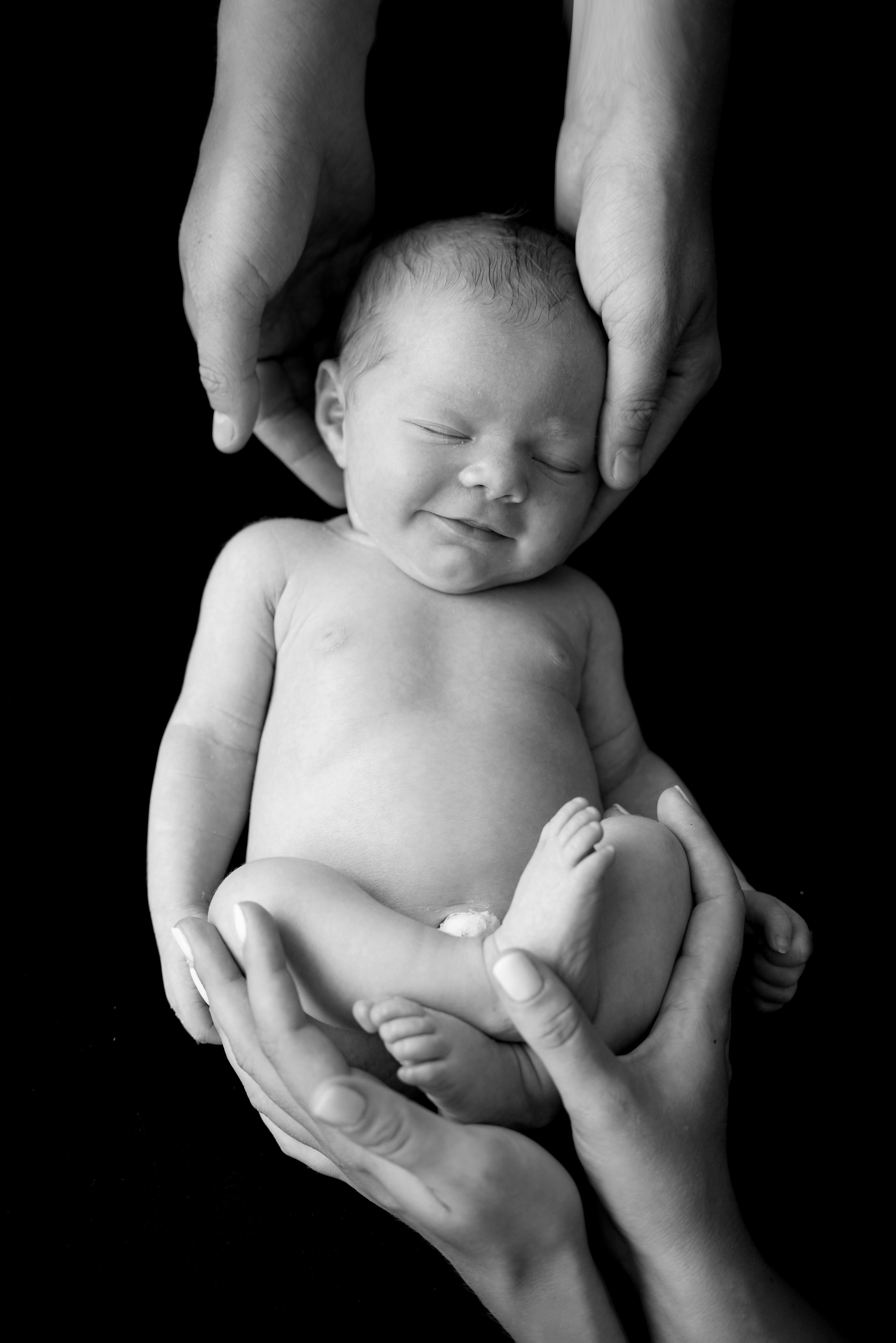 Schwarz-Weiß-Fotografien eines nackten Babys in den Armen eines Elternteils