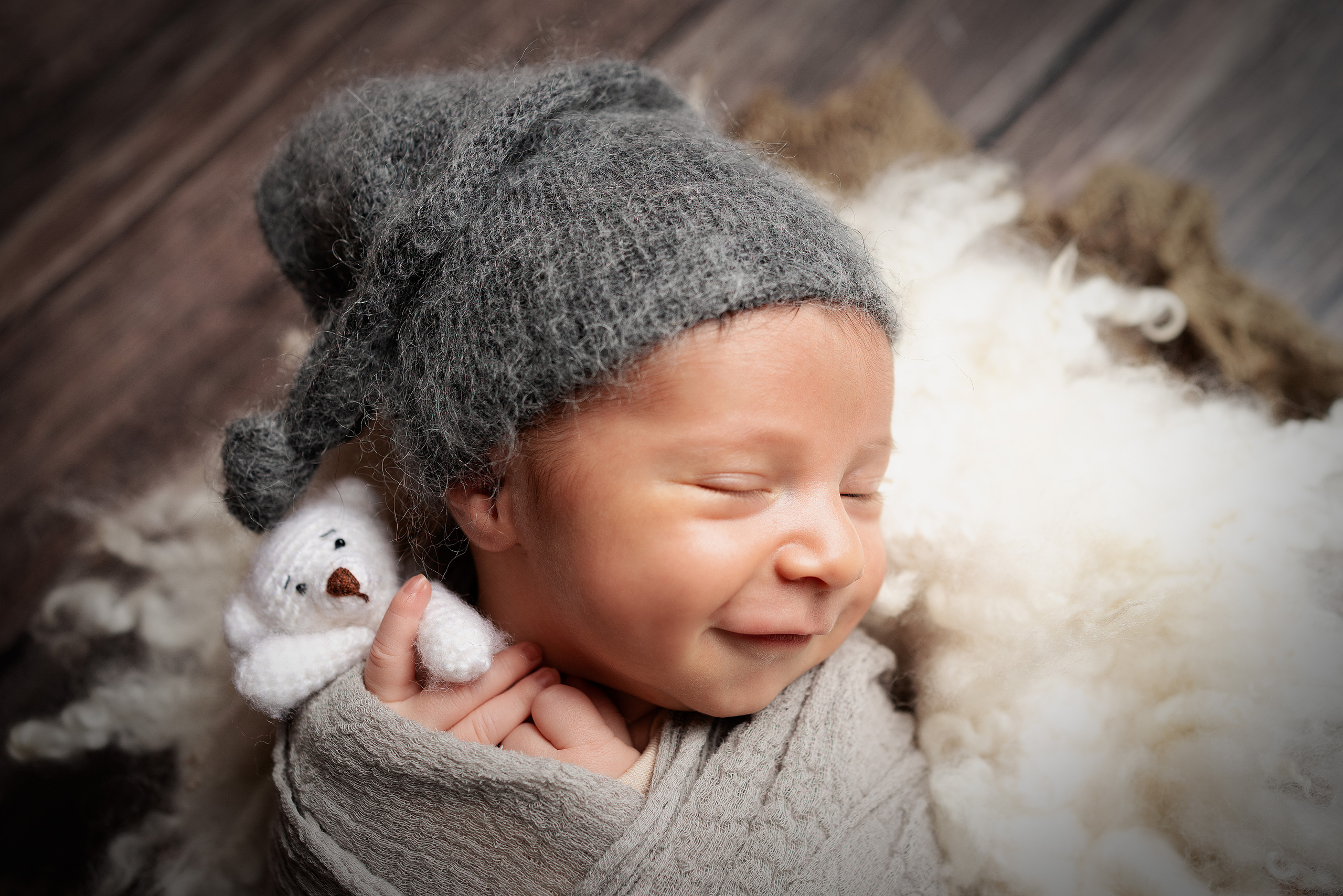 lächelnder und fröhlicher Junge mit einem Teddybären