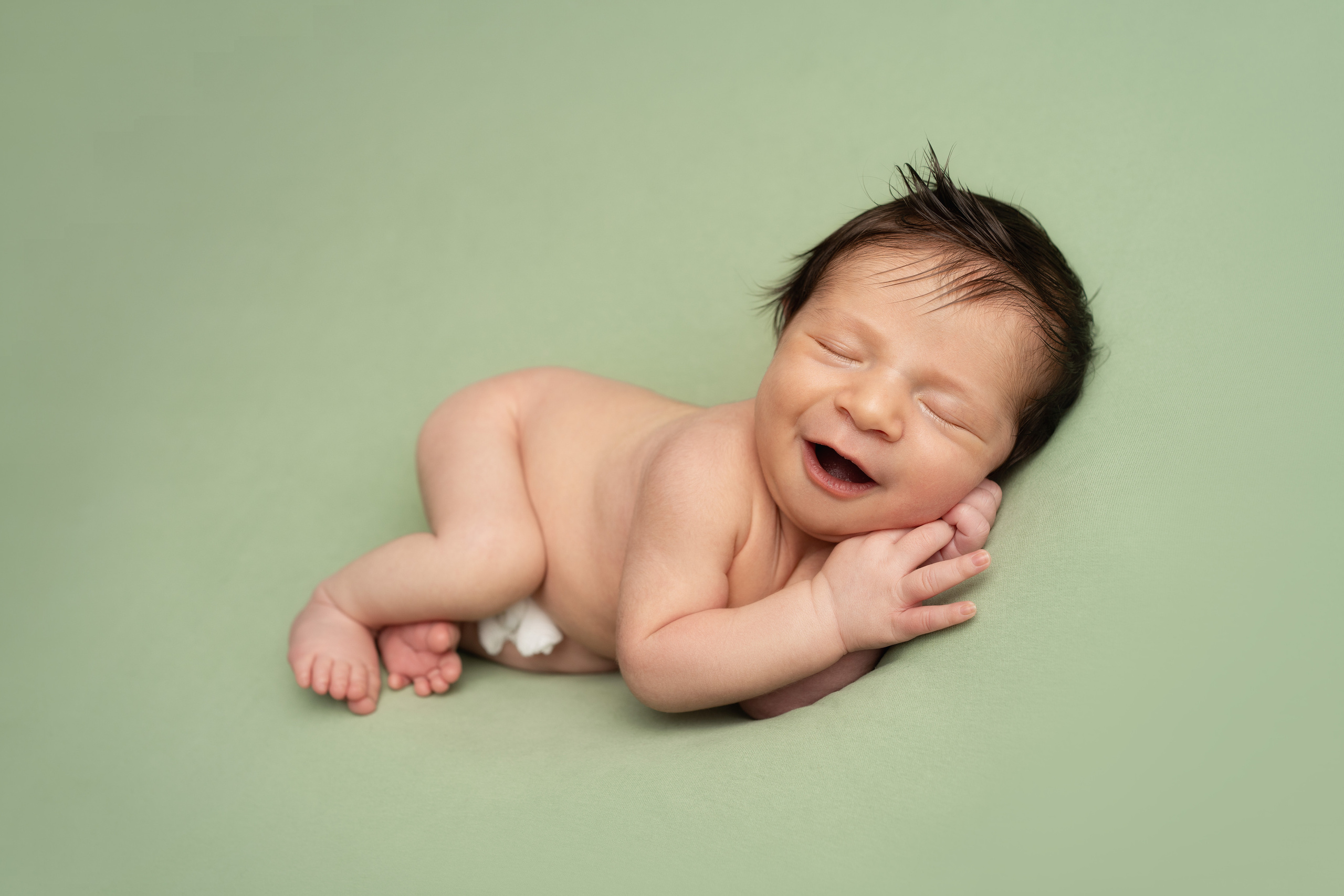 Babys erstes Lächeln bei dem Newbornshooting