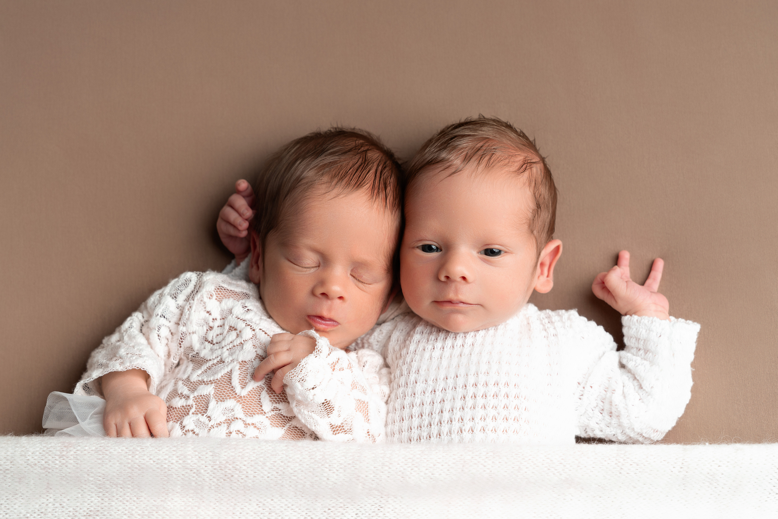 Zwei kleine Wunder: Neugeborene Zwillinge in liebevoller Umarmung