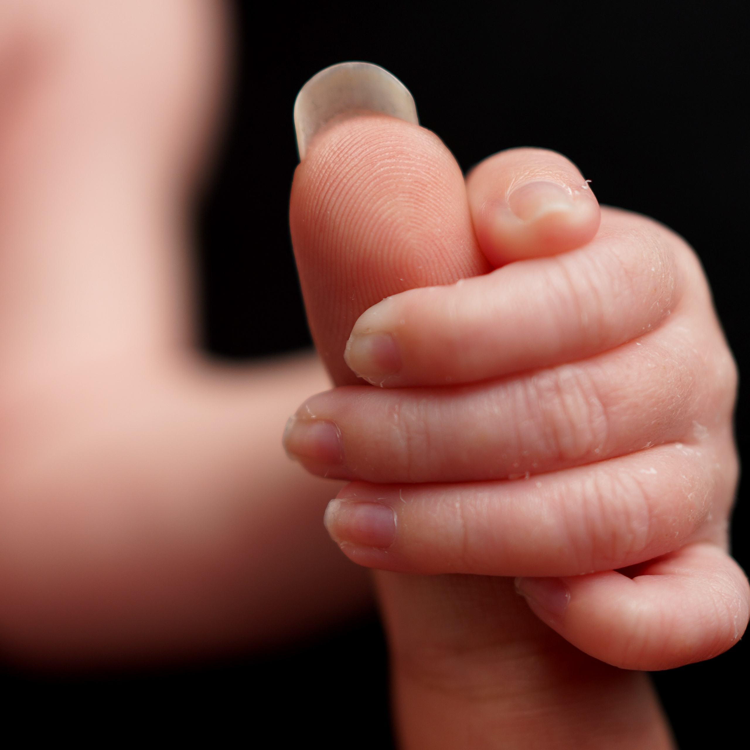 Winzige Händchen und Füßchen in liebevollen Händen