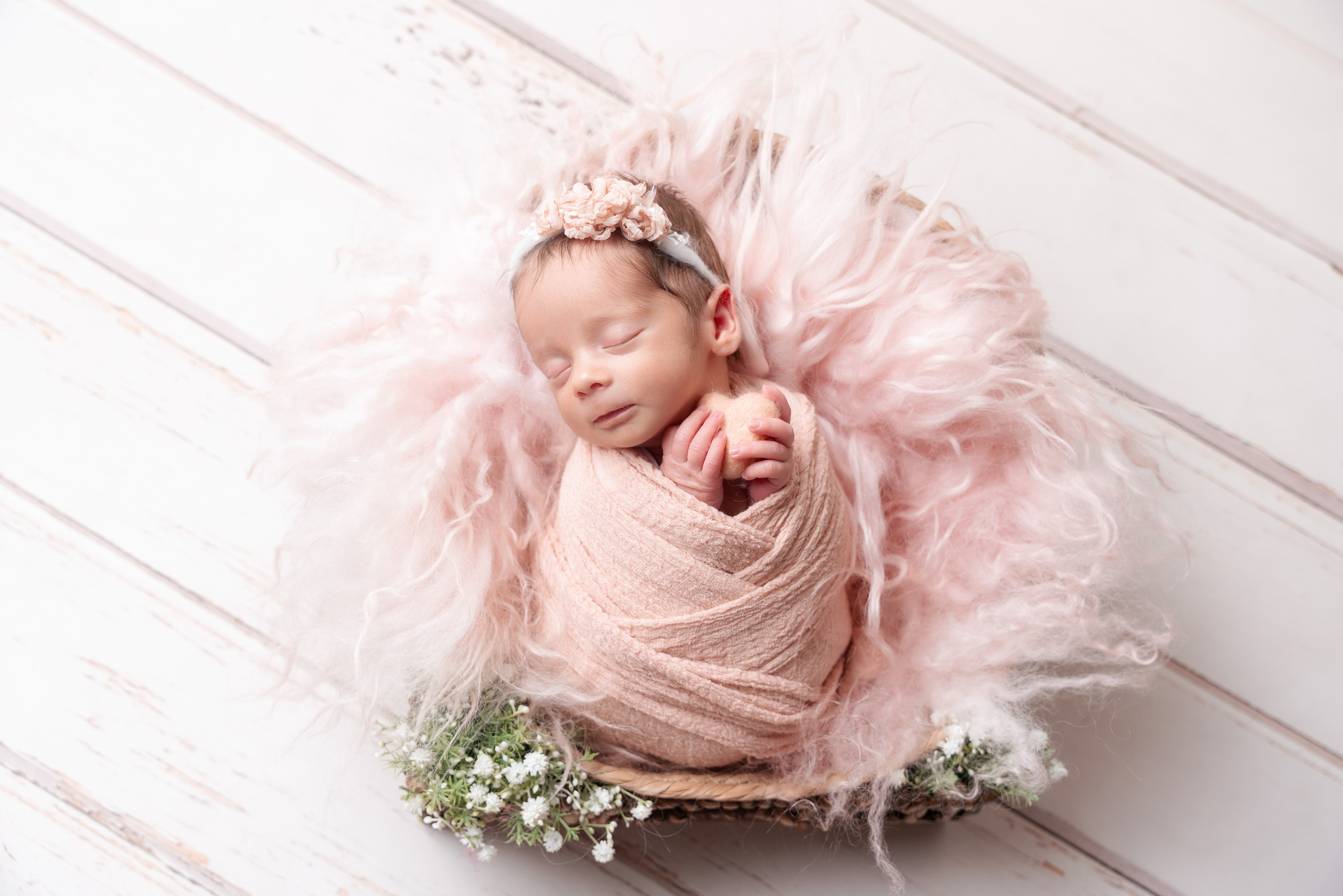 Rosa Fell und rosa Herz runden das Outfit für Newborn ab