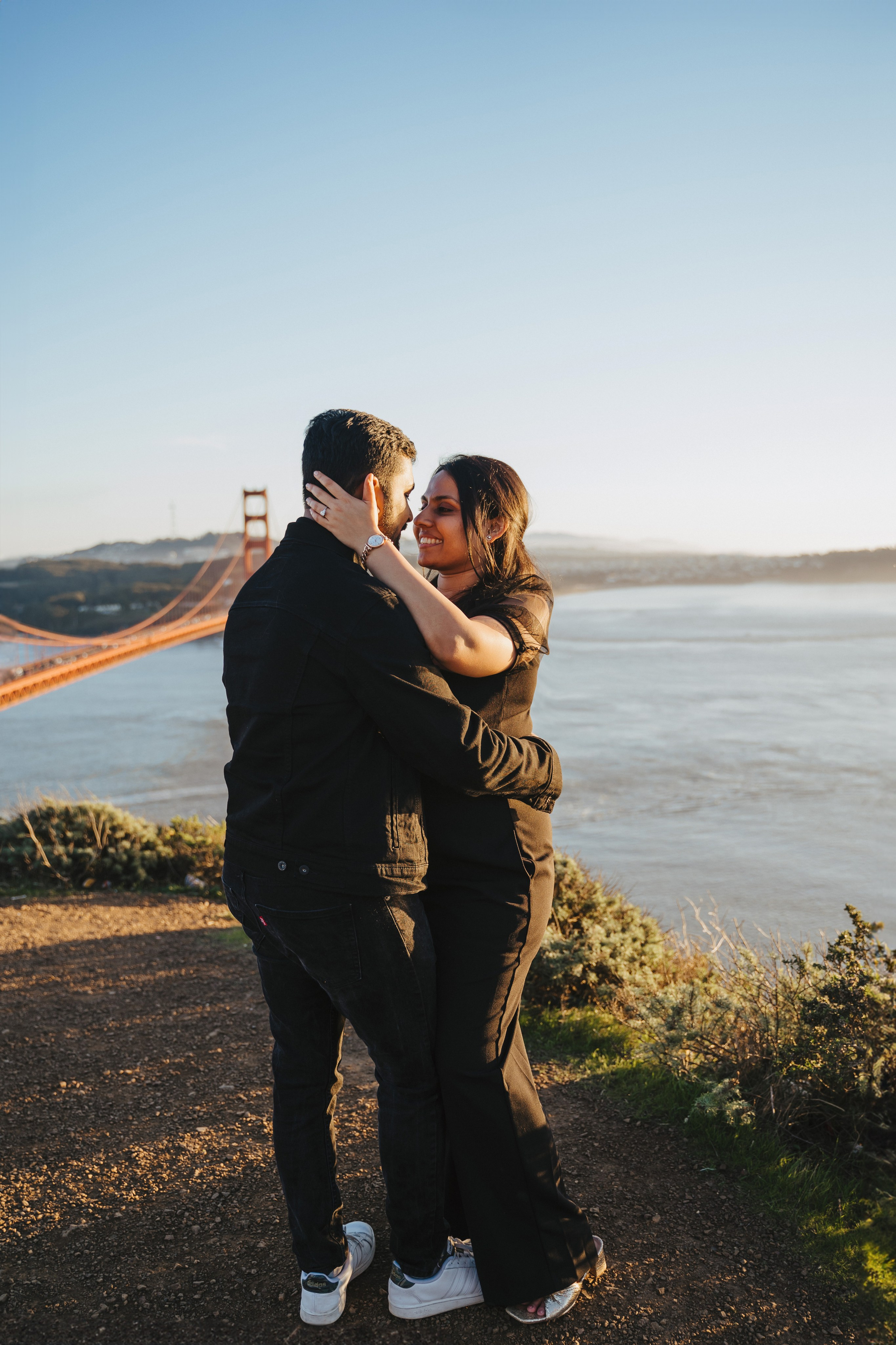 Proposal.  Overlooking the golden San Franisco Bridge sunset with a couple. Photographer Video. 