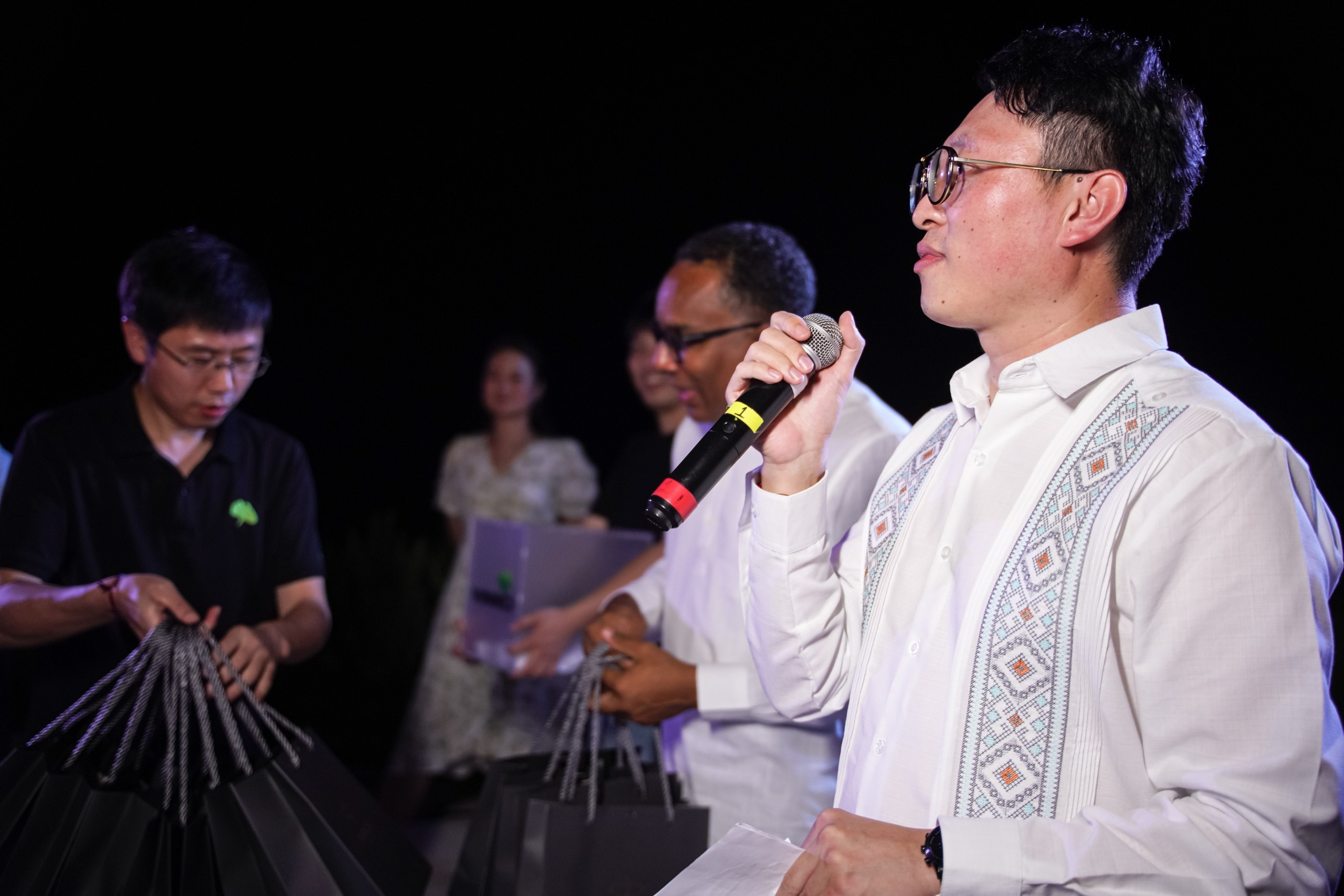 Stage presenter guiding a corporate workshop with participants watching.