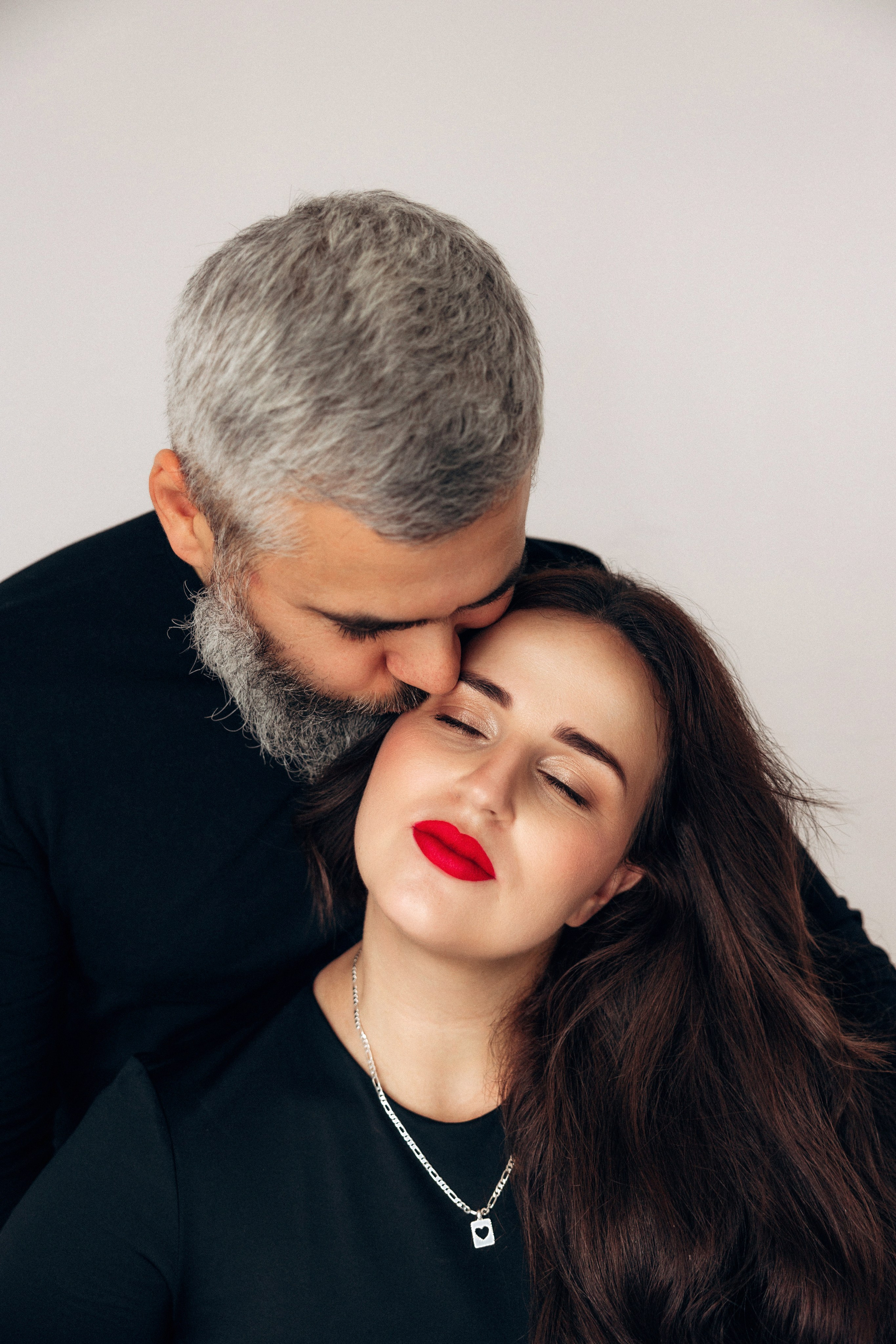  Intymny moment w sesji ciążowej – delikatny pocałunek w skroń, spokój i uczucie między przyszłymi rodzicami.