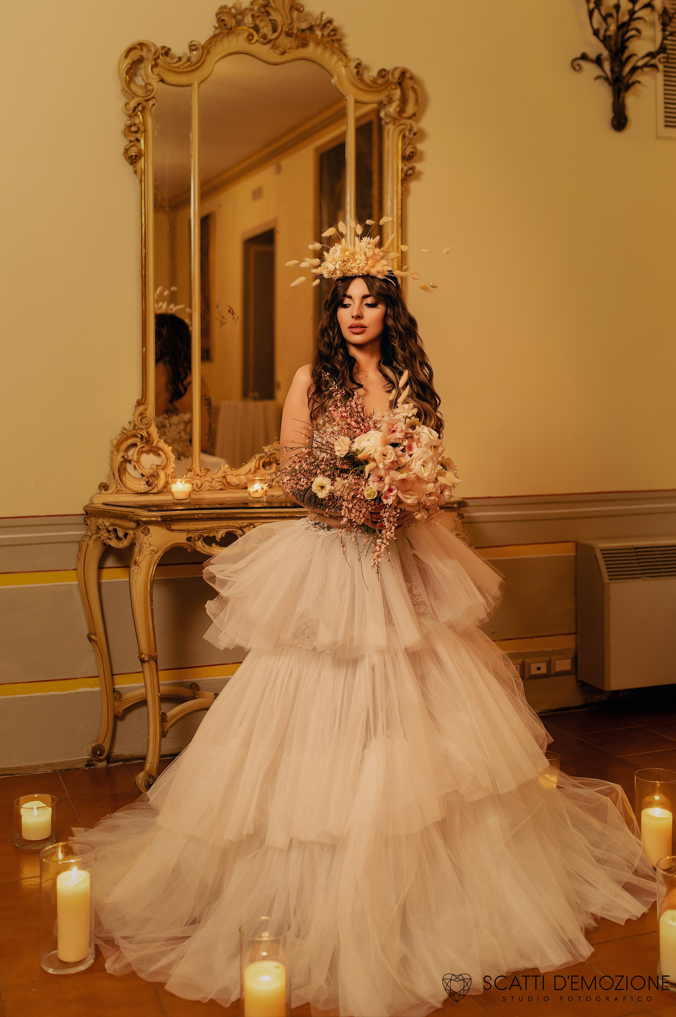sposa ritratto davanti ad uno specchio di lusso in un ambiente romantico con candele