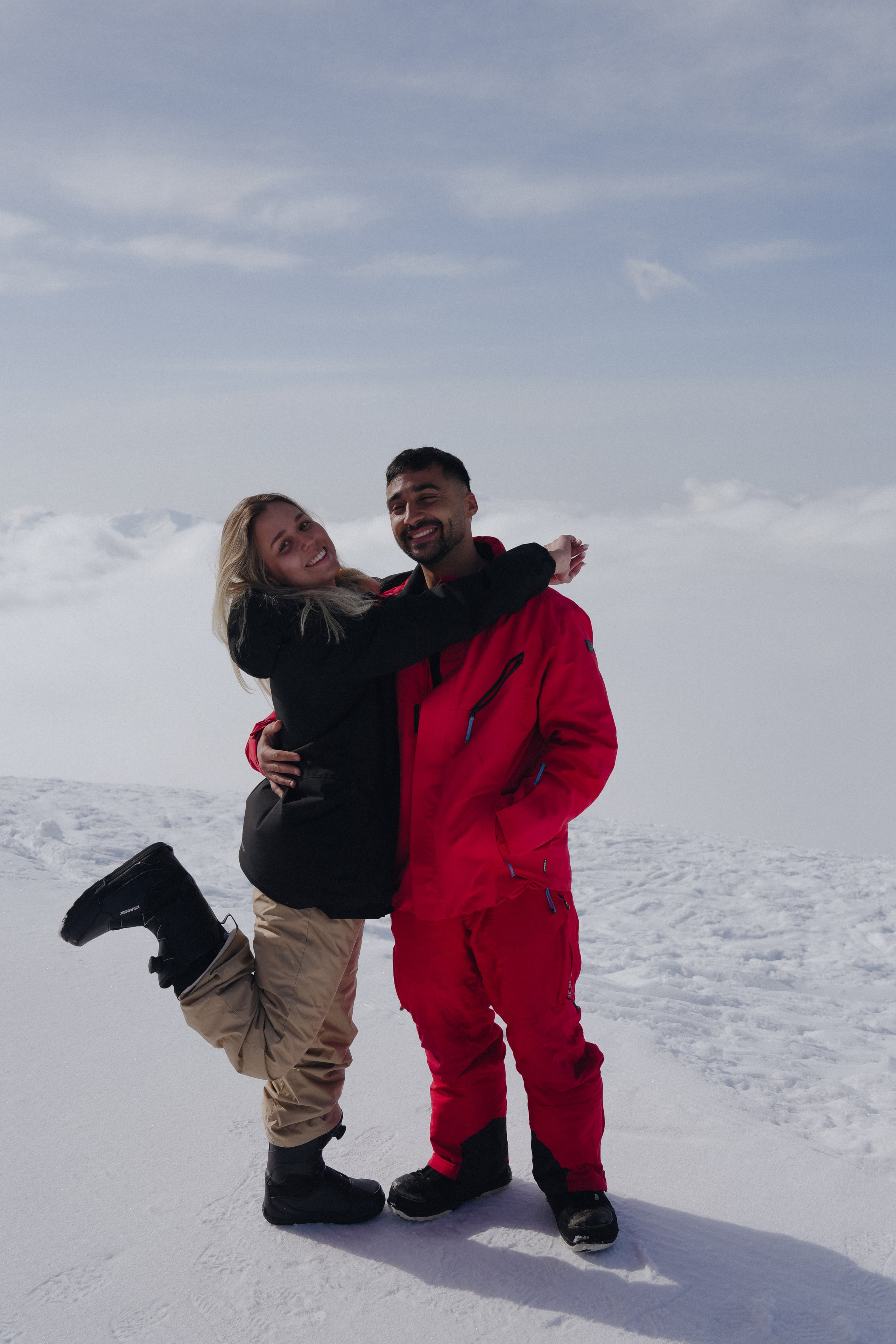 Young couple during surprise snowboard proposal at Gudauri ski resort