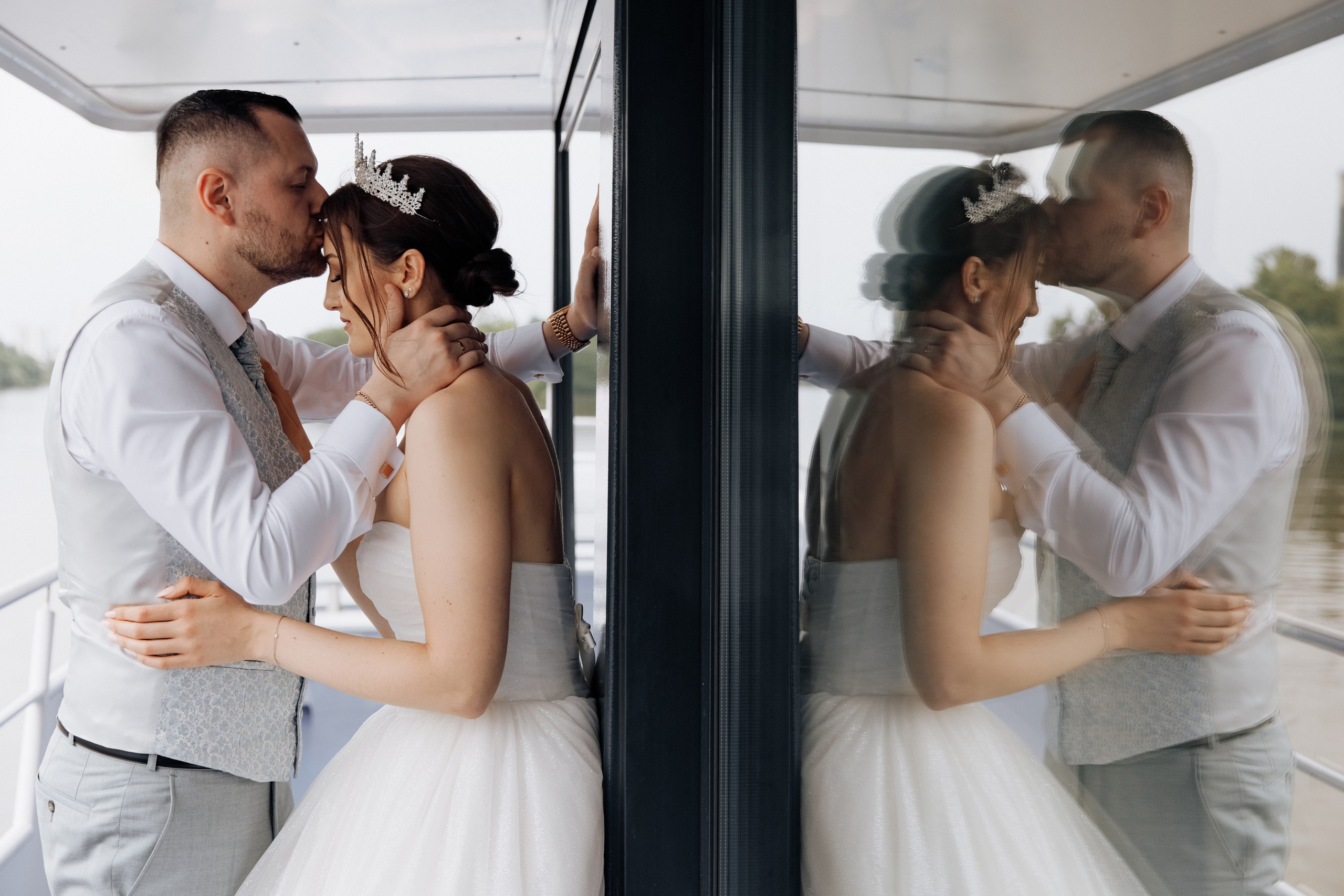 Der Bräutigam küsst die Braut auf die Stirn auf dem Deck des Hochzeitsschiffes.