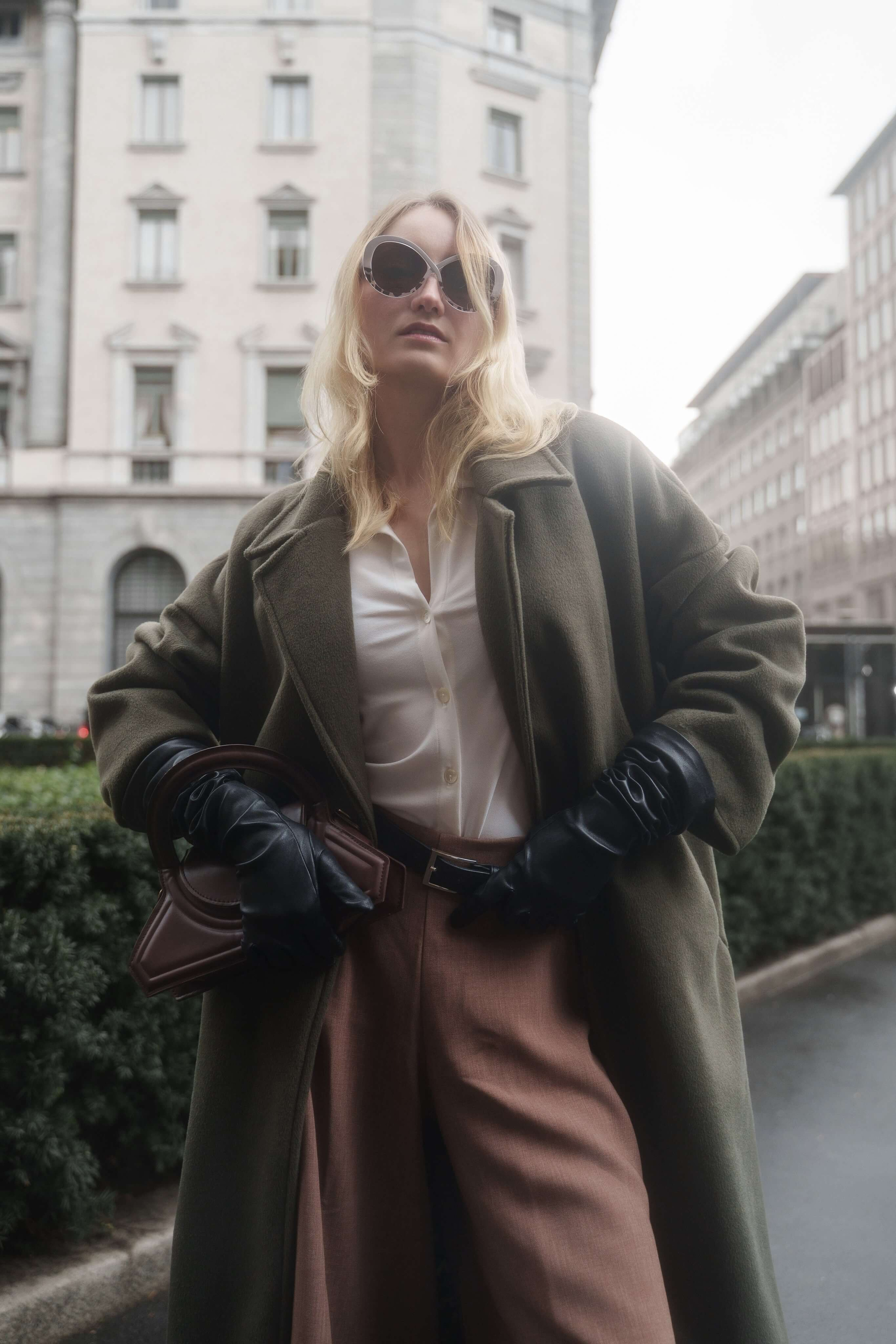 Brand photoshoot in Italy – fashion model wearing statement eyewear and green coat in urban setting