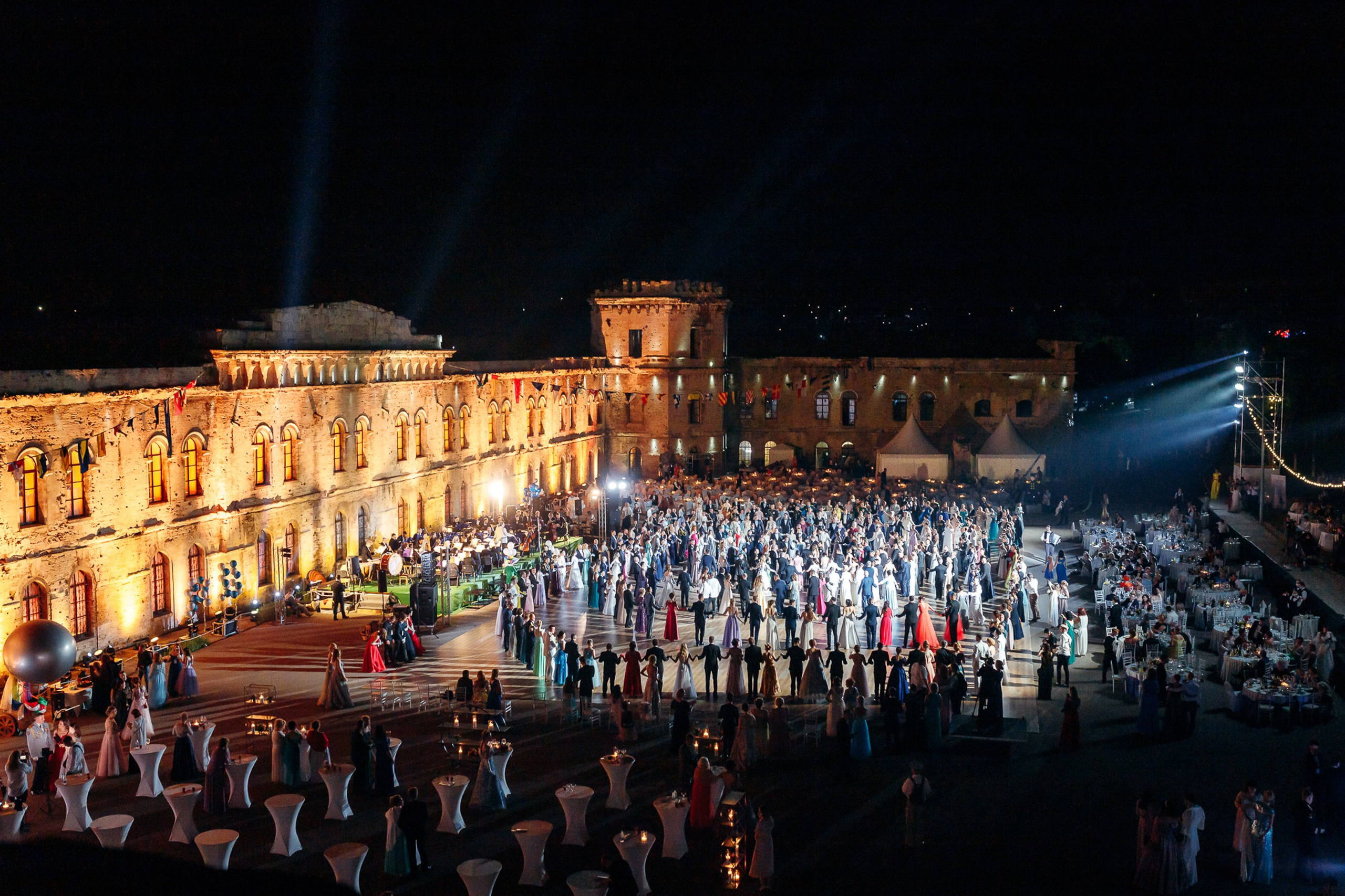 Large outdoor event with stage and crowd at night