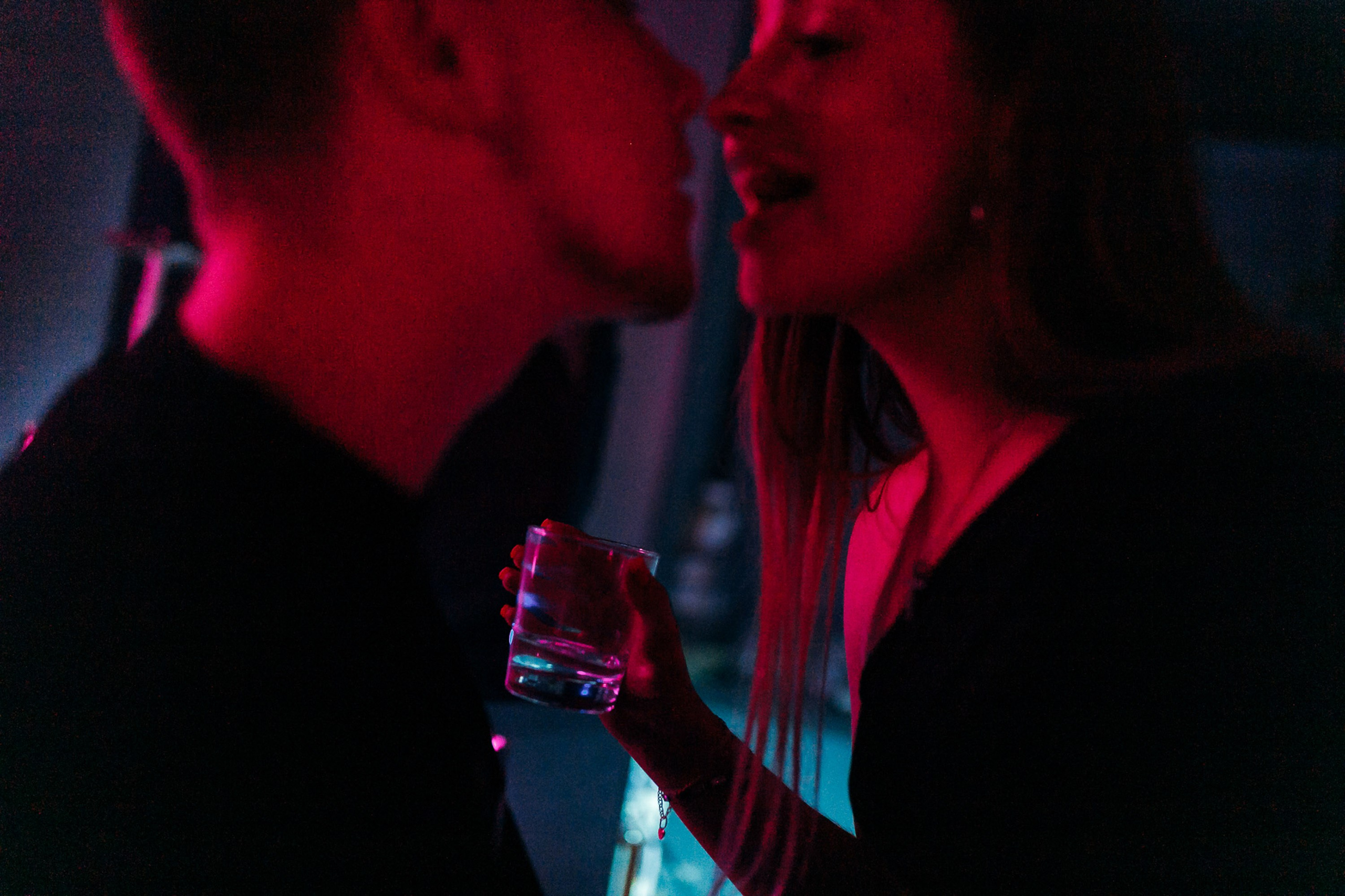 Close-up of couple dancing under red lights