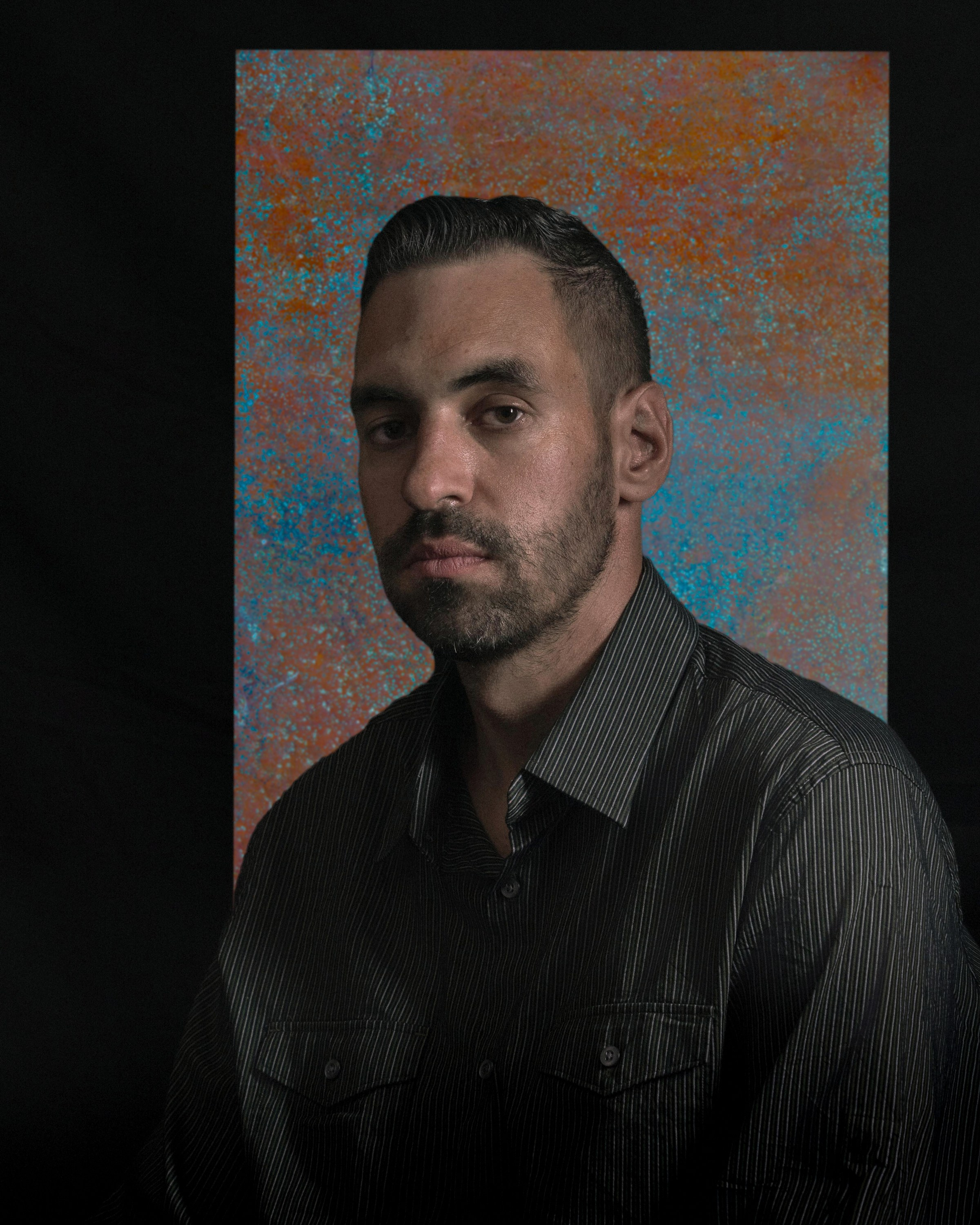 Low-key male portrait with dramatic lighting against a textured background