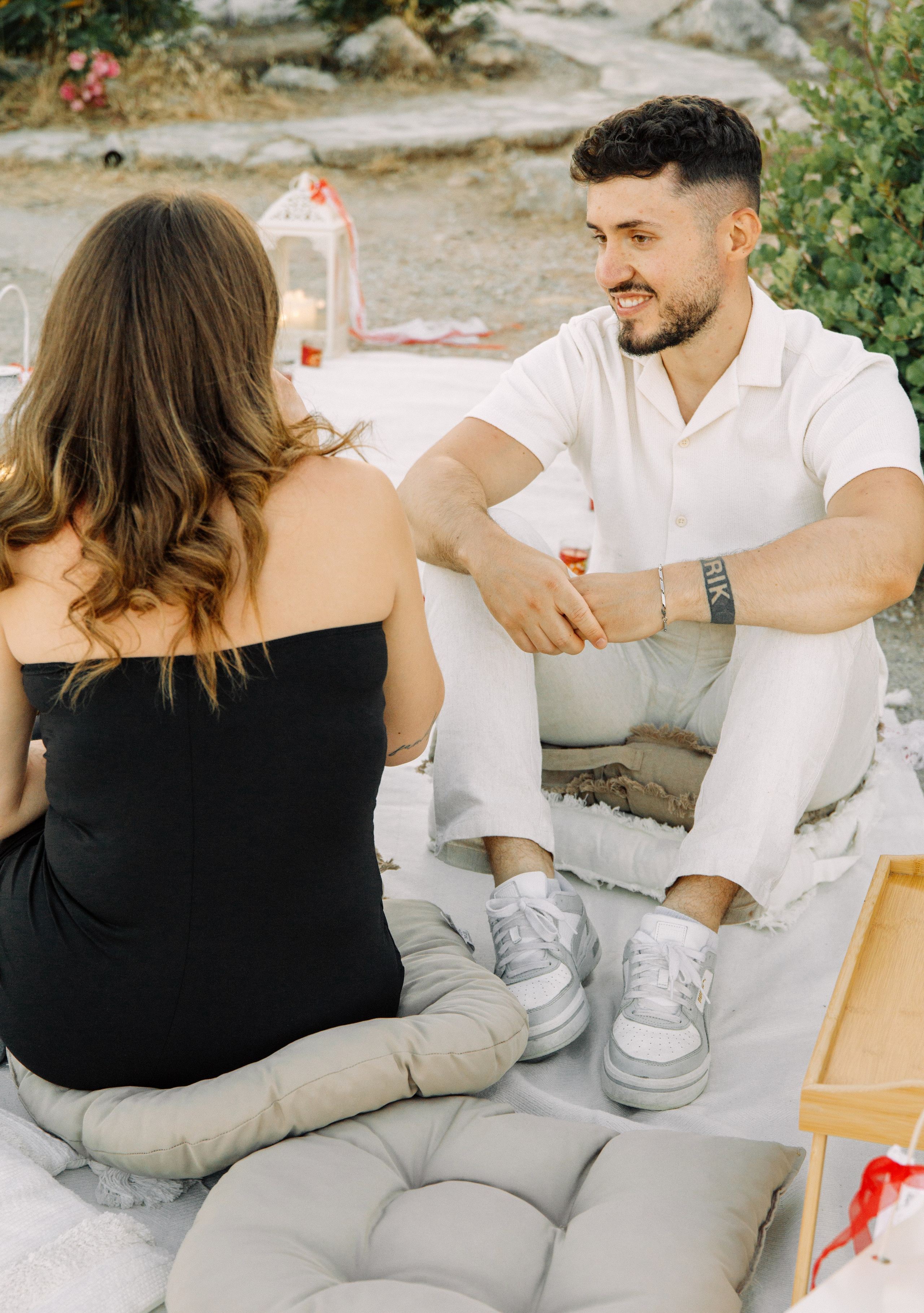 "Liebevoller Blickkontakt: Ein Paar auf dem Felsplateau des Profitis Ilias vor der Kulisse von Faliraki und dem Mittelmeer."