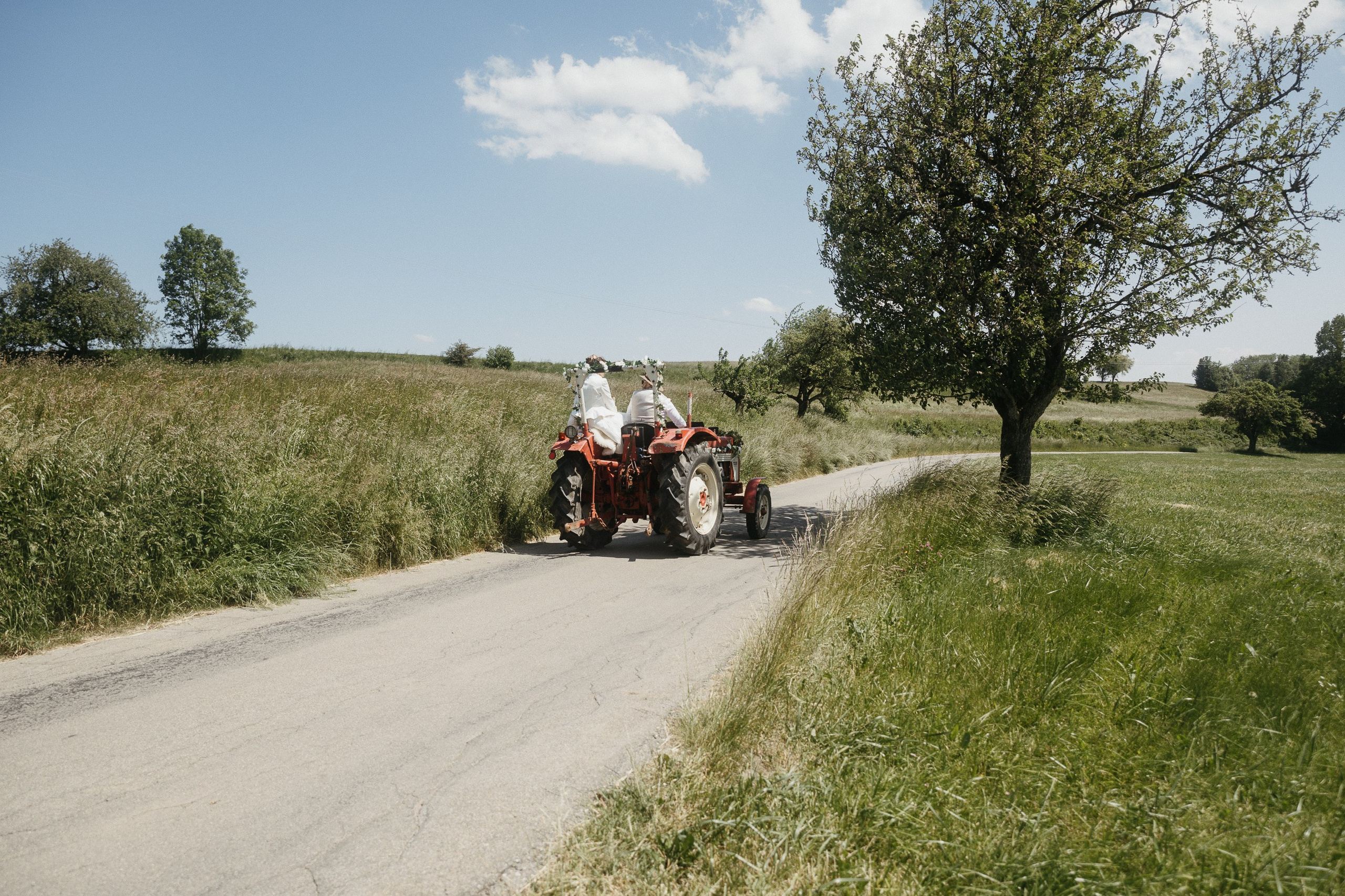 Paar fährt Oldtimer-Traktor durch Landschaft in Baden-Württemberg