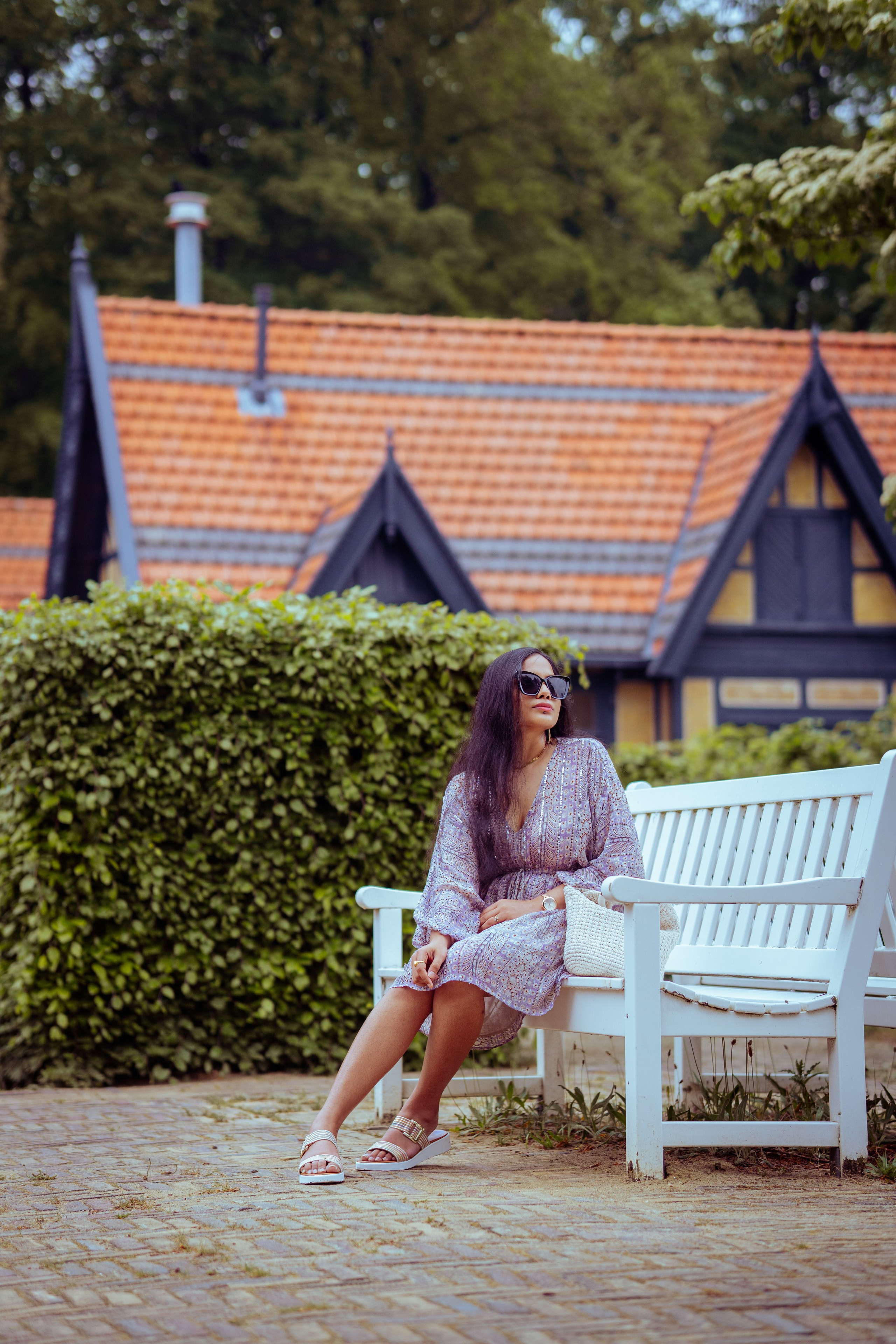 woman sitting on a white bench in a park