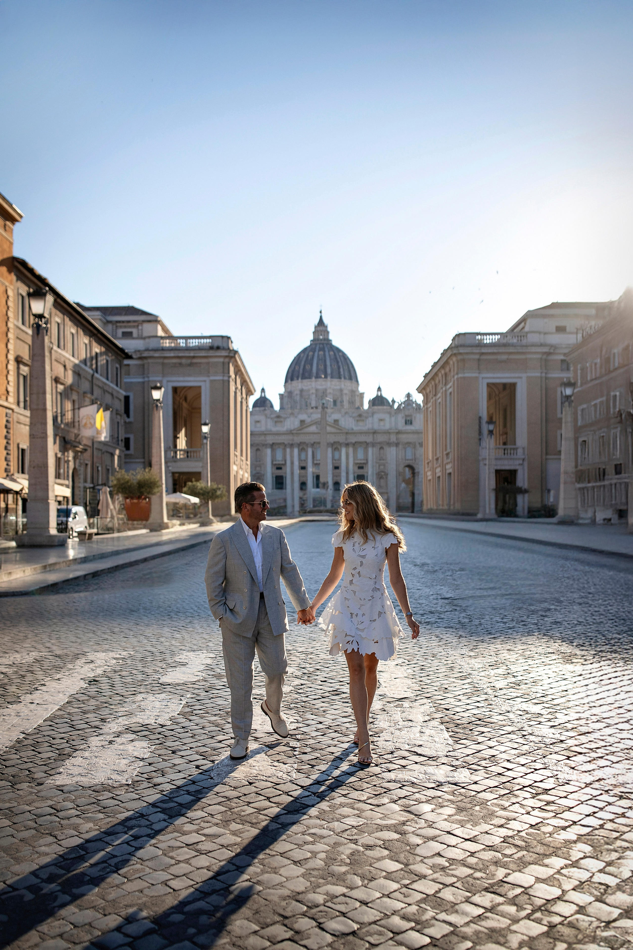 Couple walking during a photoshoot with St. Peter's Basilica in Rome