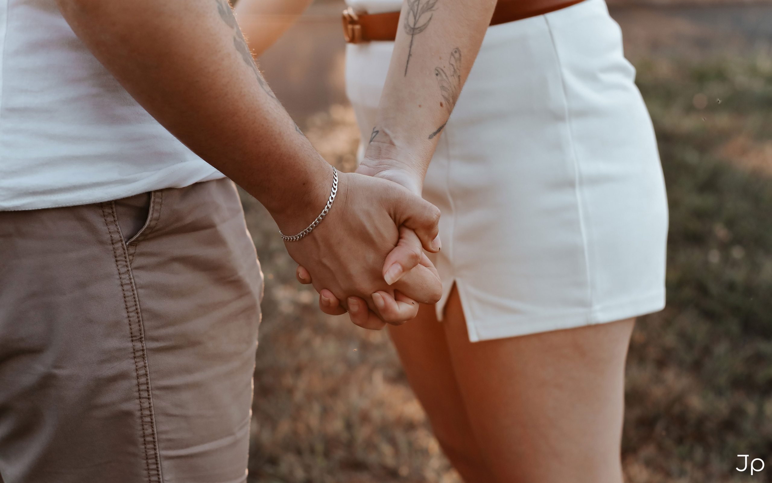 Detalhe das mãos dadas, caminhando juntos.