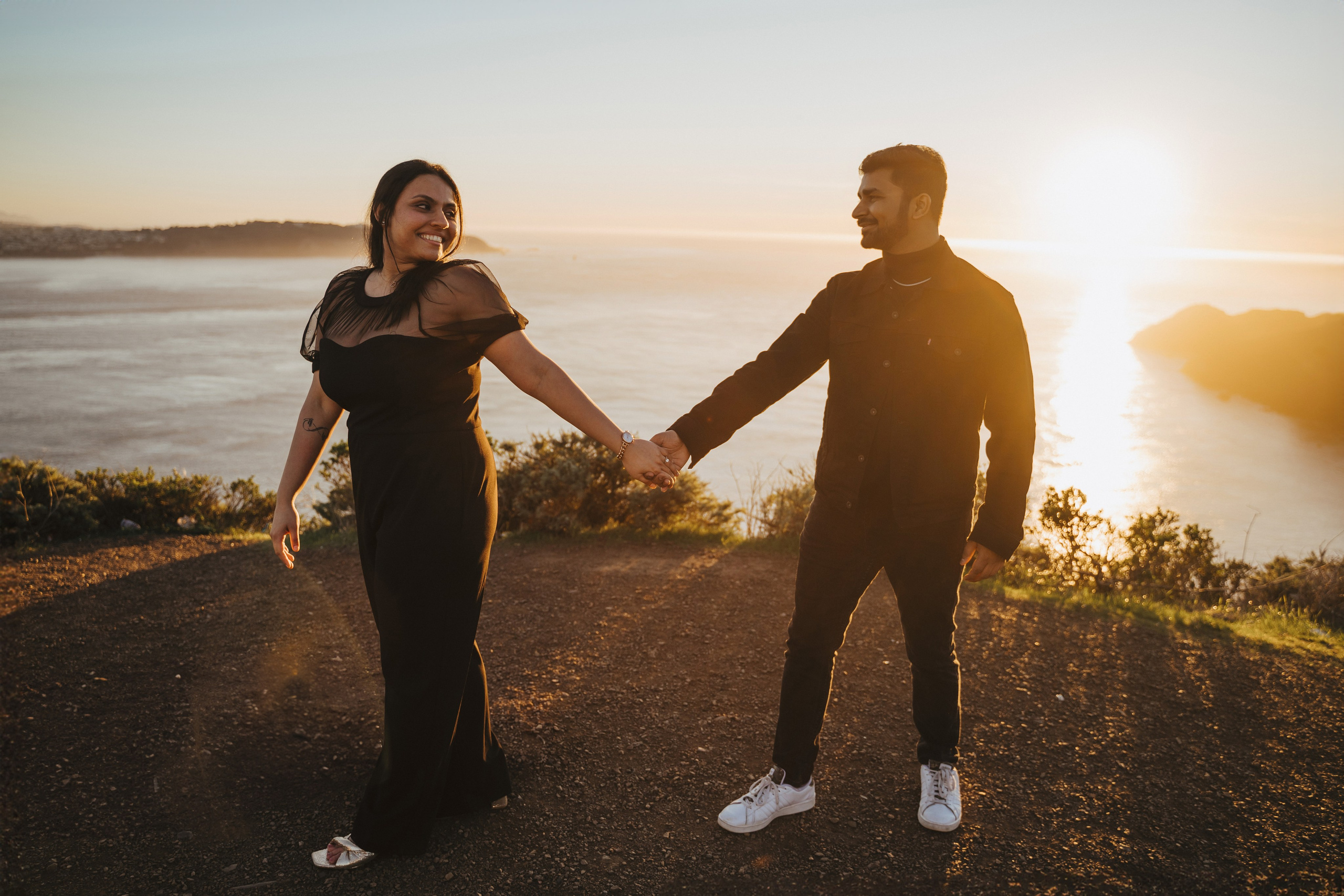 Proposal.  Overlooking the golden San Franisco Bridge sunset with a couple. Photographer Video. 