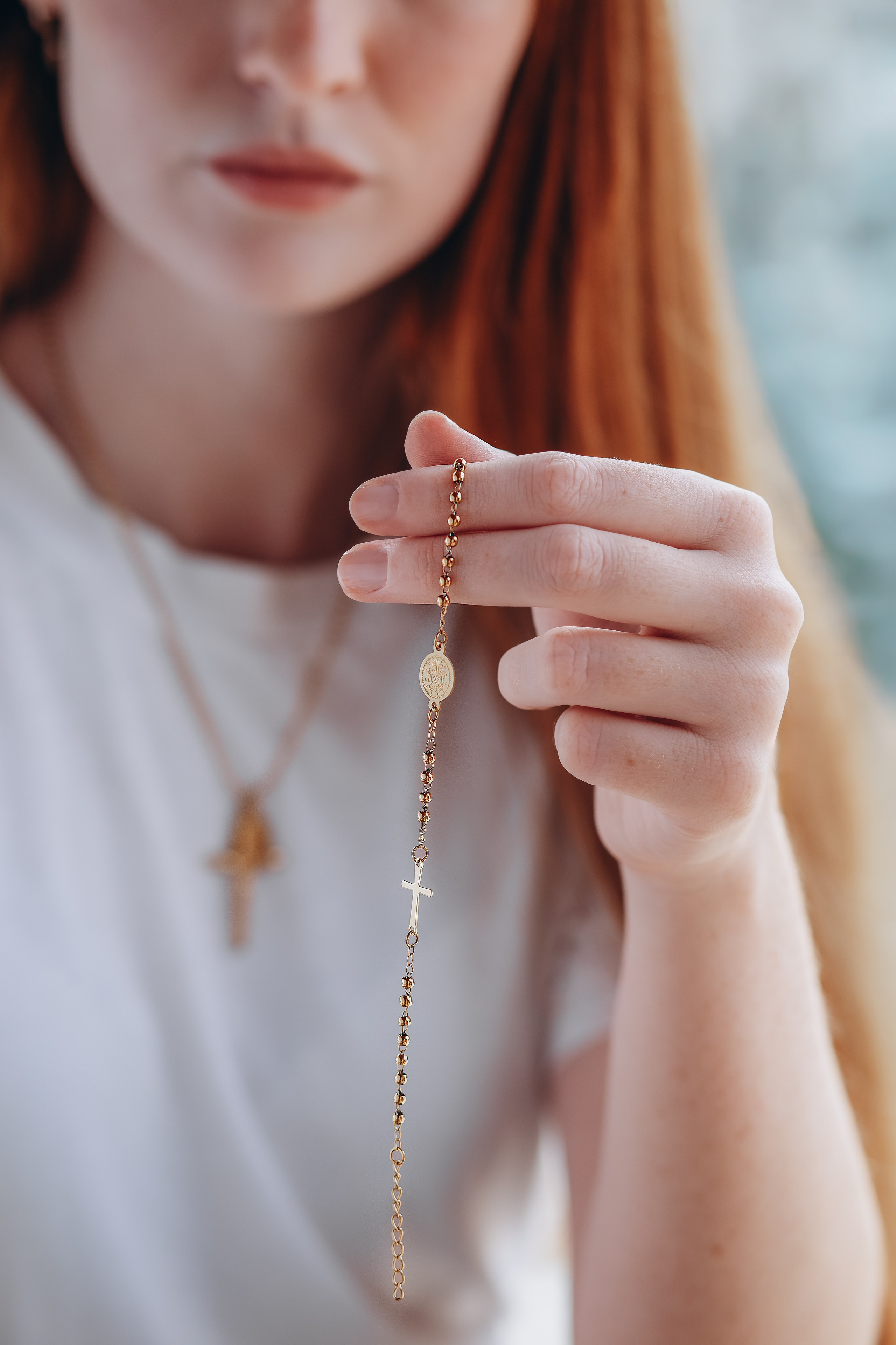 Close-up brand photo of a woman holding a delicate gold bracelet with cross detail, captured in Valencia, Spain — ideal for showcasing handcrafted jewelry in product and content photoshoots for brands seeking elegant visual storytelling across Spain.