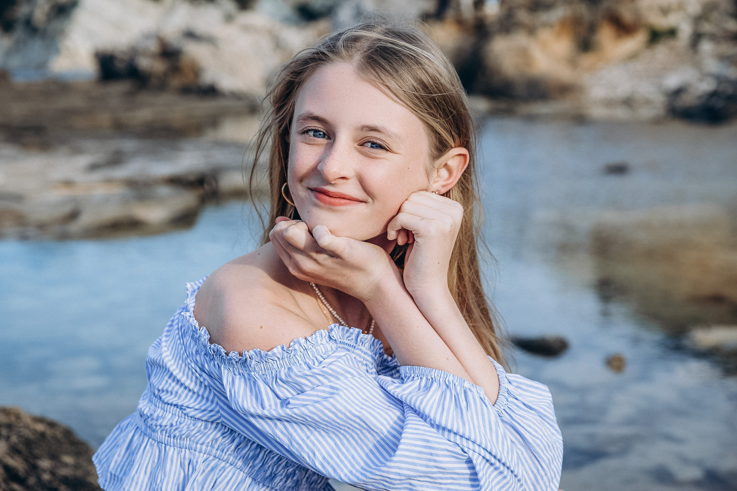 Sesión de retrato femenino en Valencia, España, con una mujer posando junto a la costa mediterránea bajo suave luz natural. Capturada con una expresión relajada y un estilo elegante frente a un pintoresco paisaje costero. Este retrato femenino y atemporal resalta la belleza natural, la confianza y las emociones auténticas, ideal para fotografía de retrato femenino, sesiones individuales, marca personal y retratos lifestyle en Valencia y toda España.