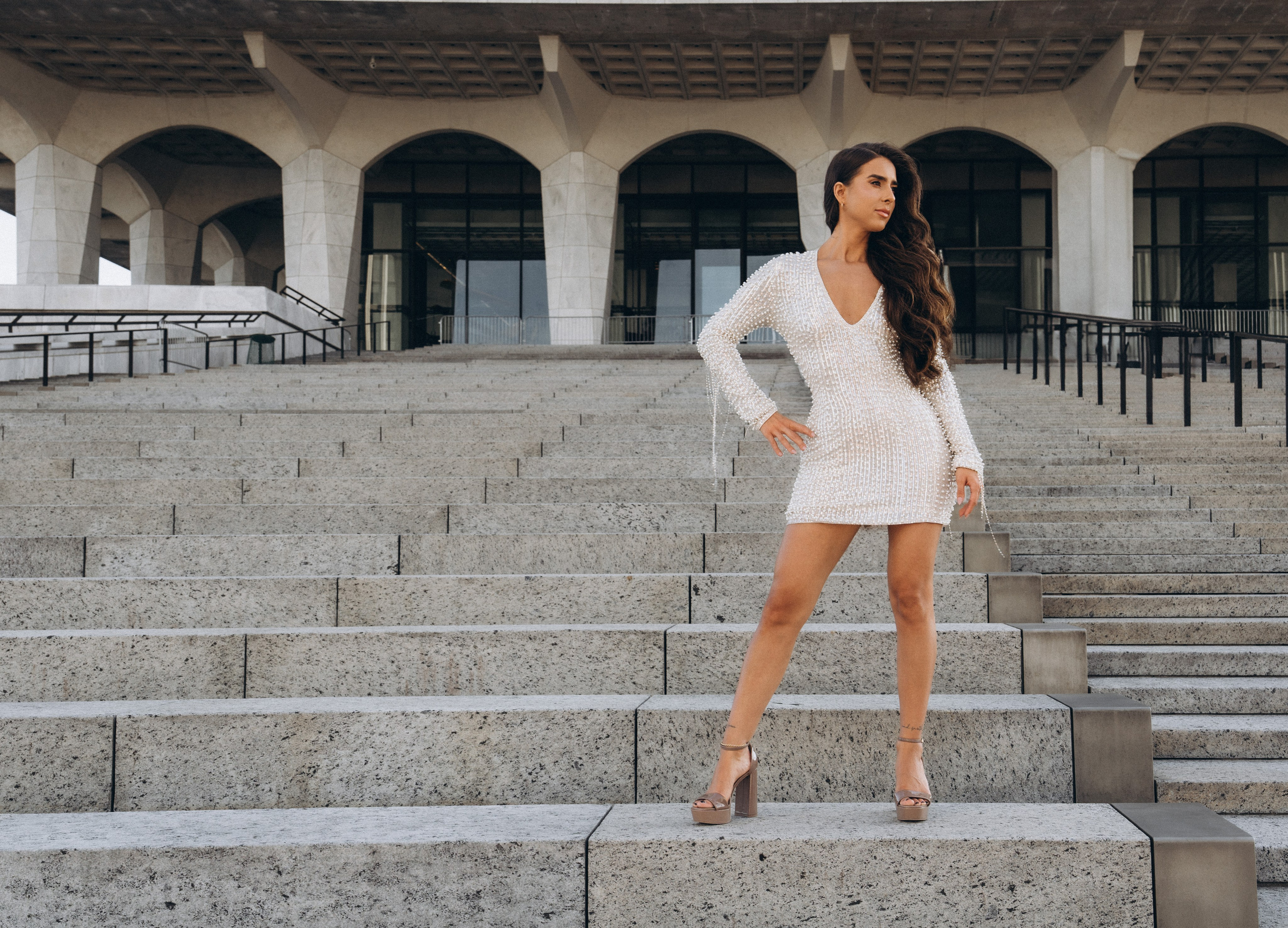 Bride walking under Adirondack pine trees.