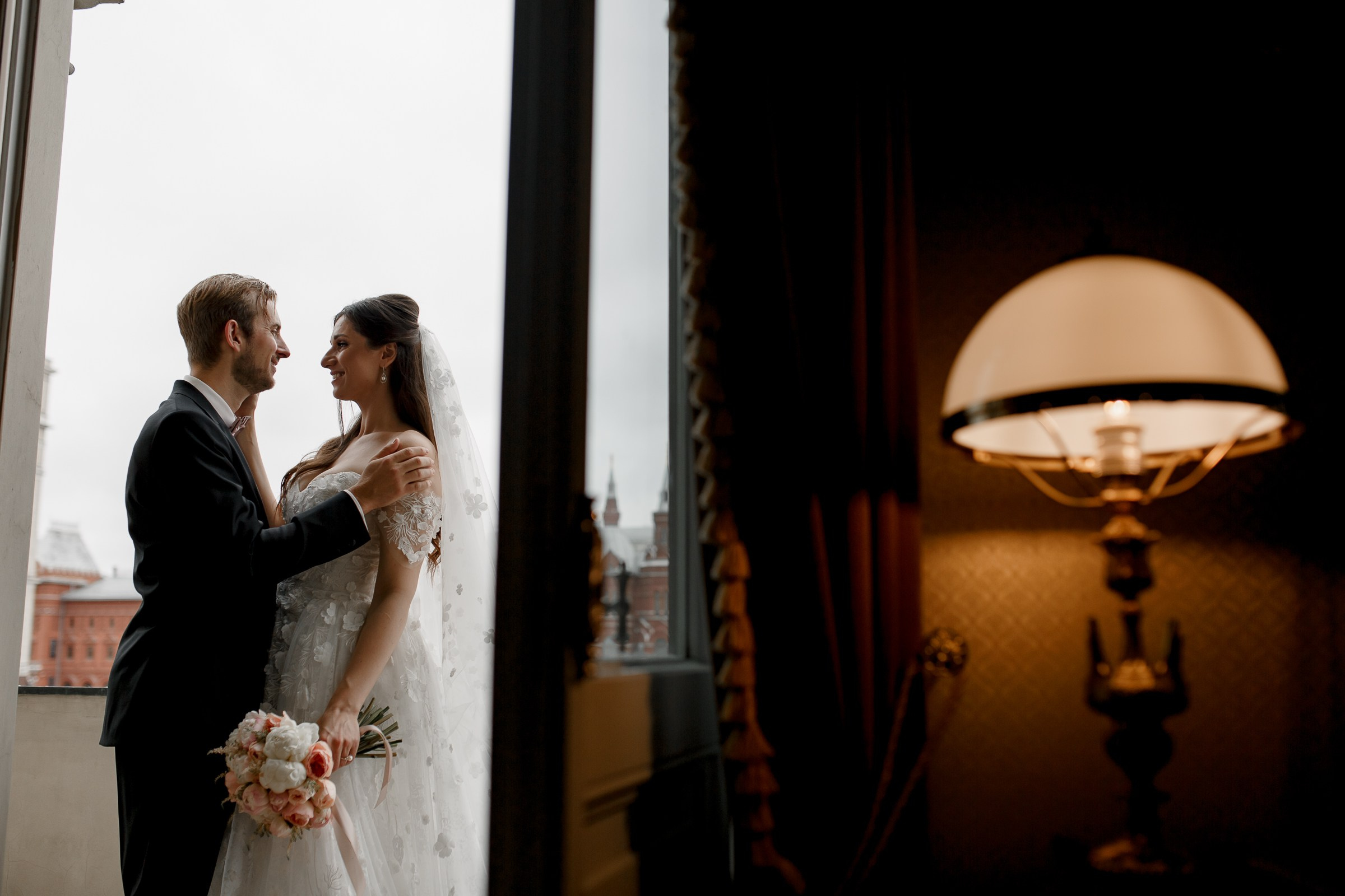 Couple’s morning hug on balcony, by Bude, wedding photographer.