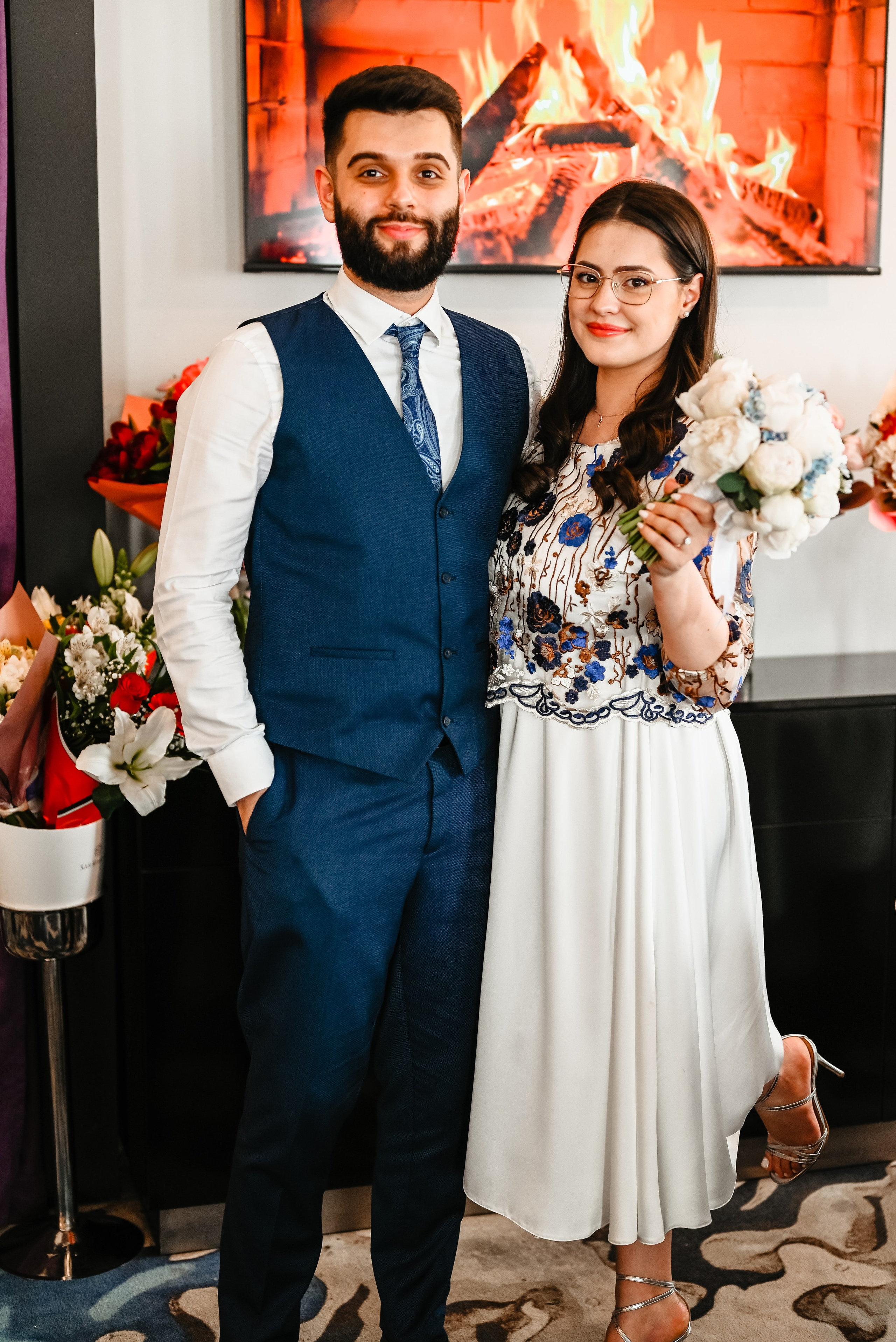 Mireasa în rochie albă cu decoratiuni florale și mirele elegant, ținându-se de mână în decor romantic de restaurant – stil Foto Ana Maria Drăgan