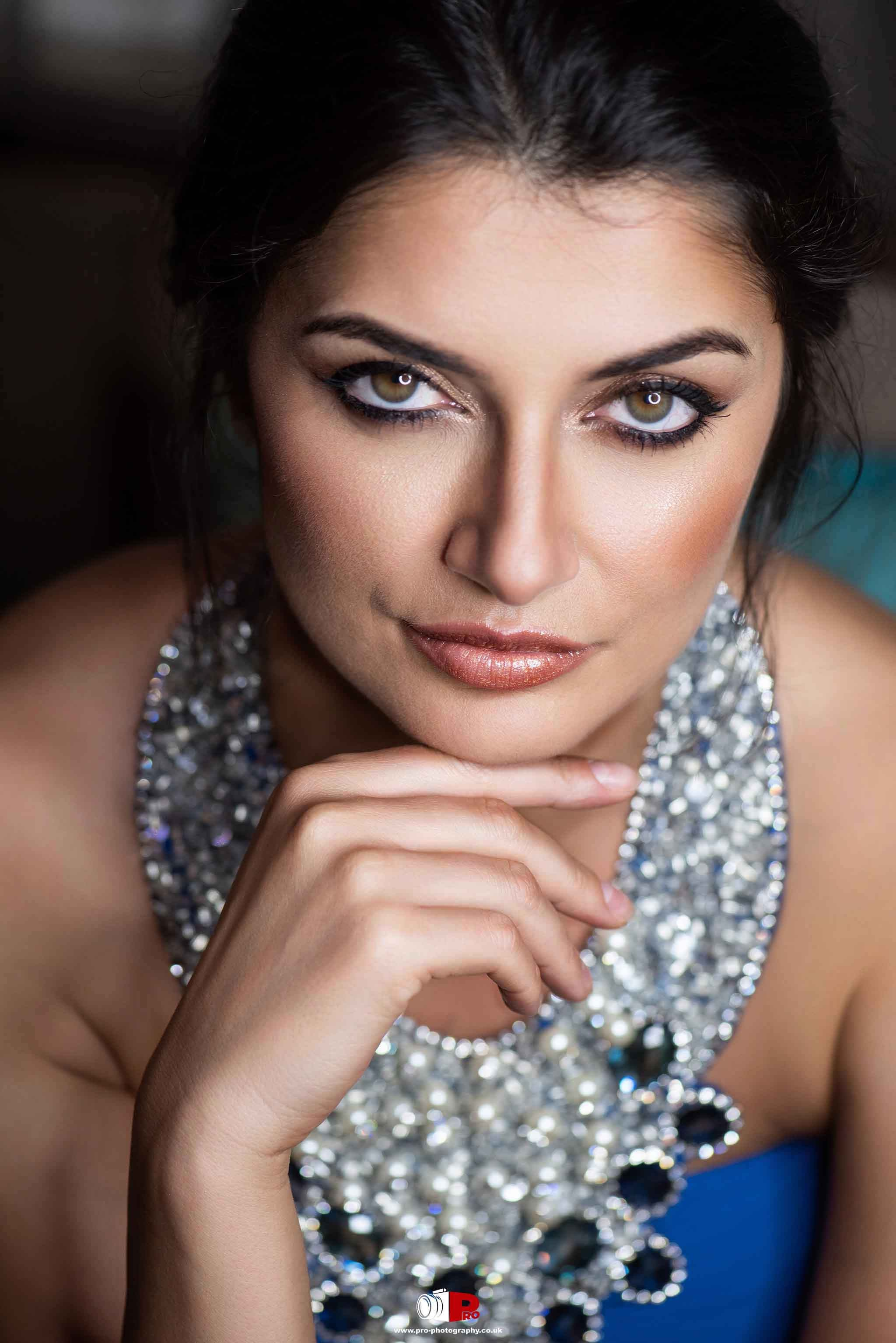 Close-up portrait of an elegant woman with sparkling jewellery, posing with a captivating look.