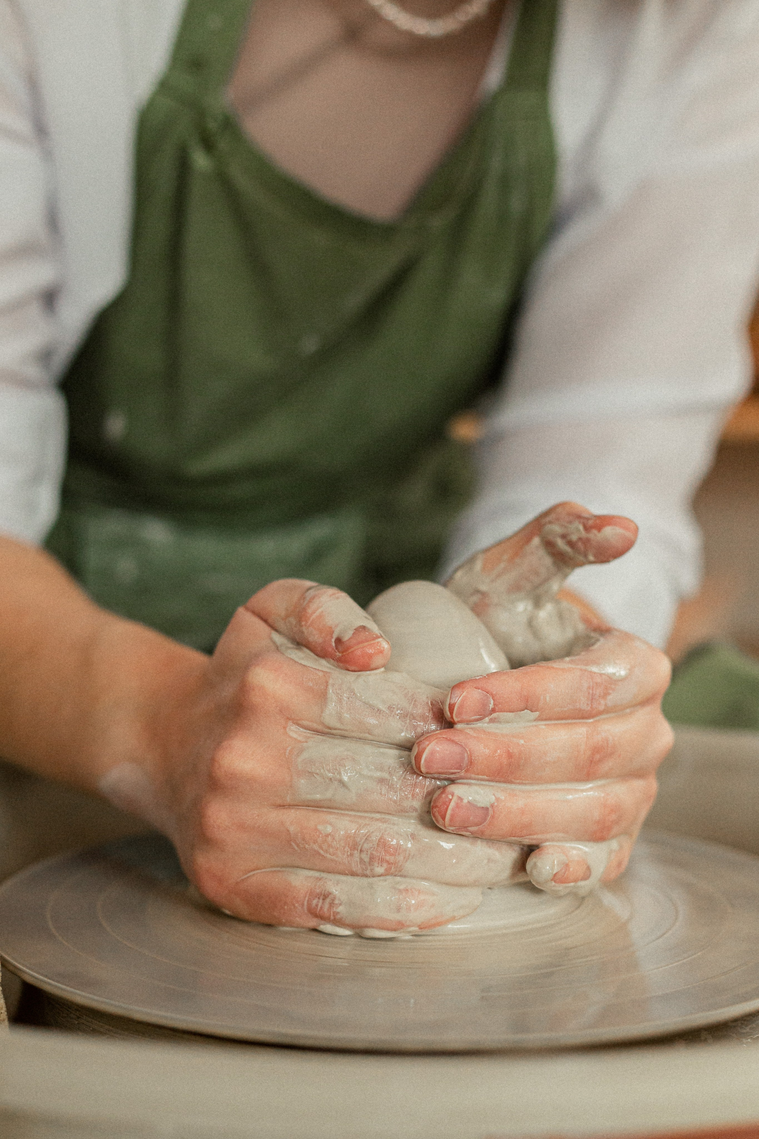 Manos sucias de un ceramista en el proceso de trabajar con arcilla