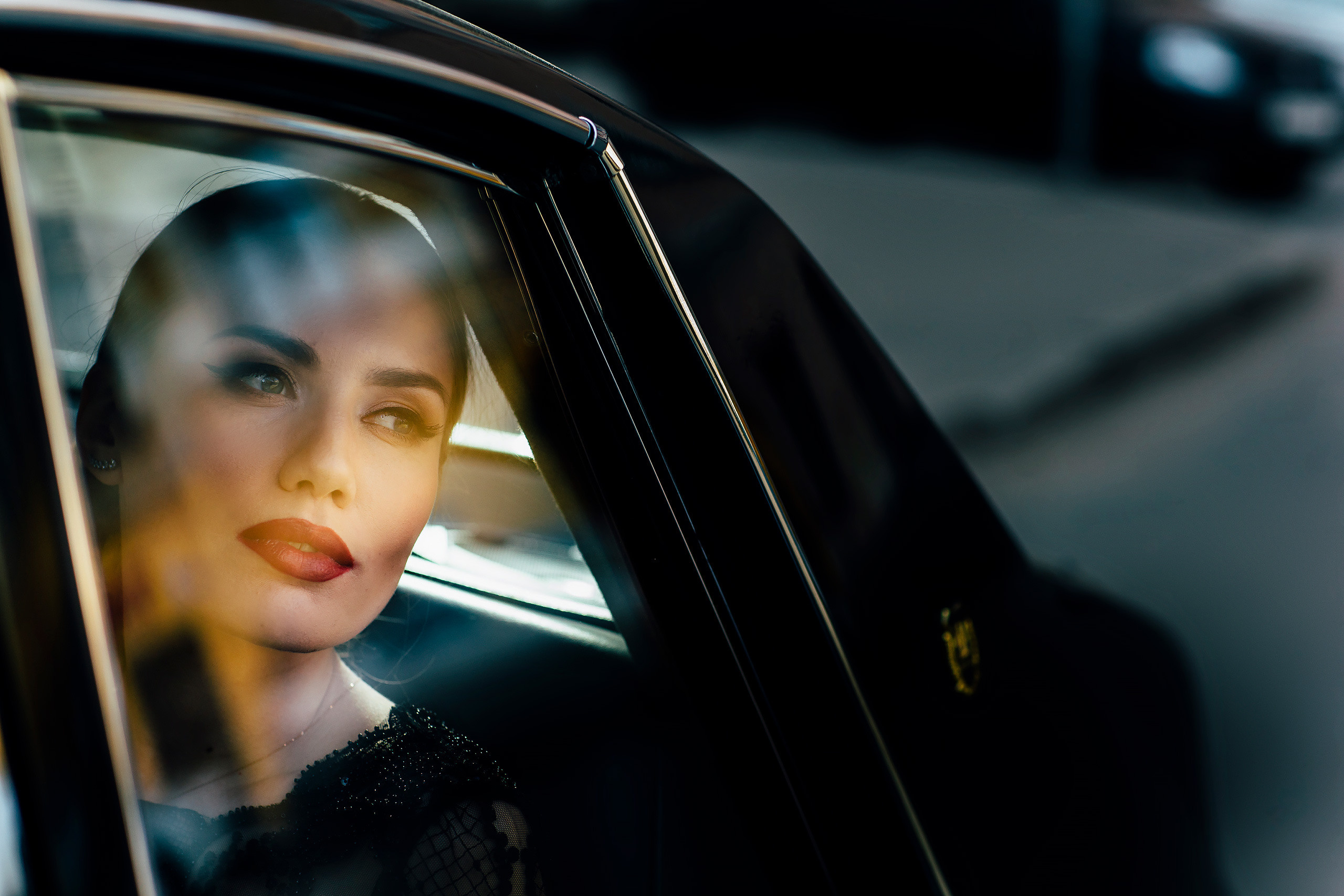 women is sitting in the car and looking aside with her dreamy eyes