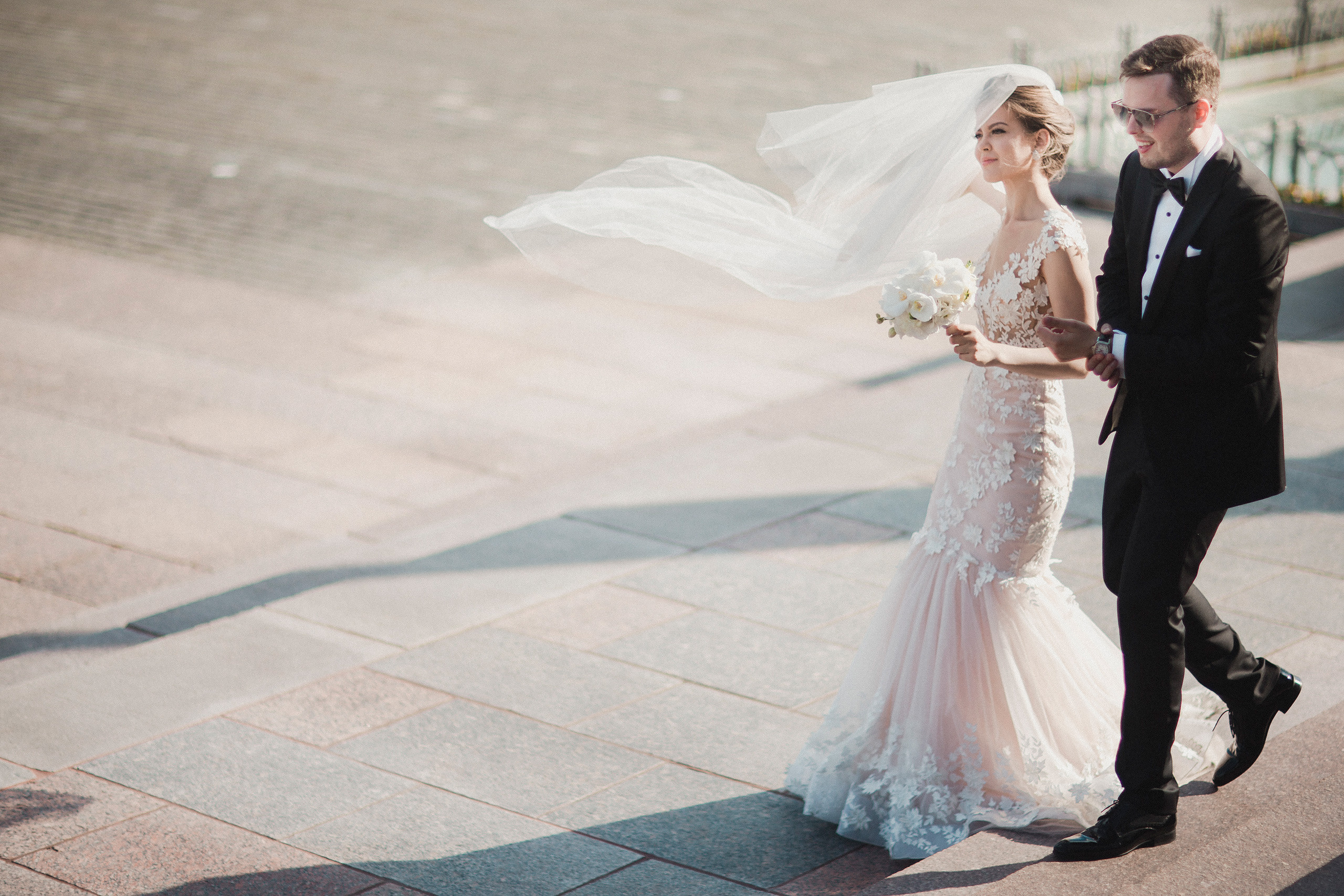 bride and groom are hugging each other while weather is very windy