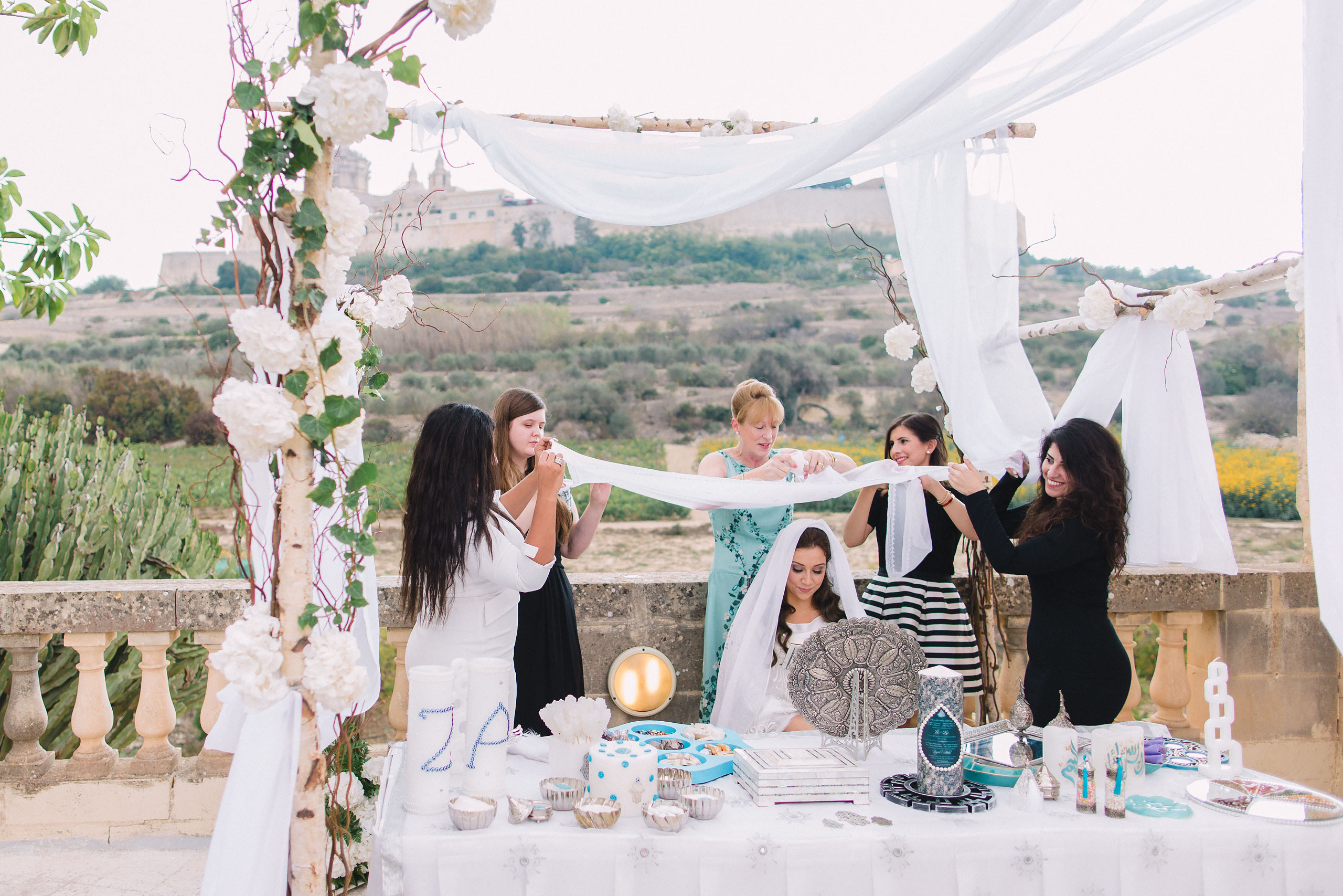 guests are helping the bride to get ready for a wedding ceremony 