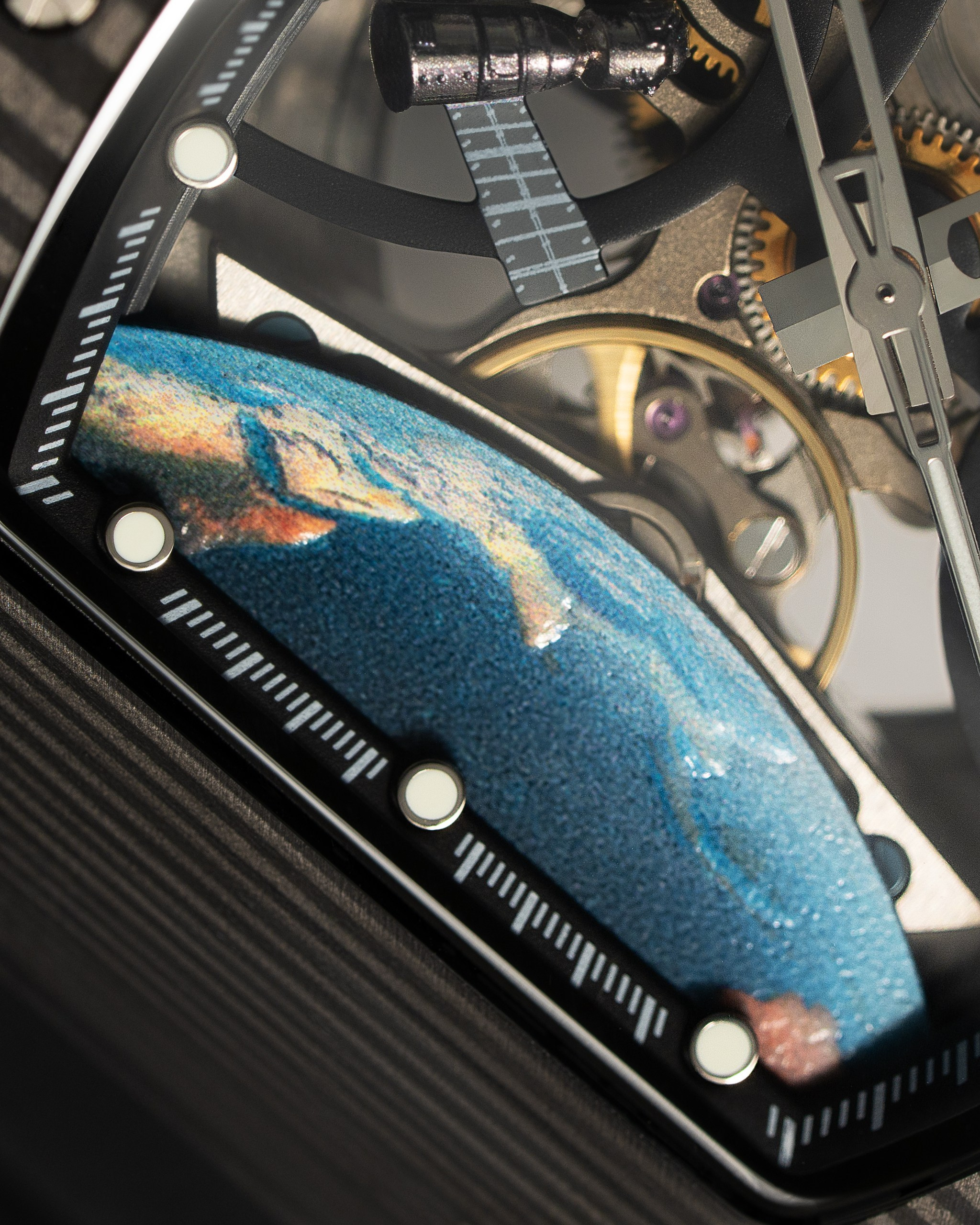 Macro shot of a luxury watch movement with rotating gears and a blue globe detail
