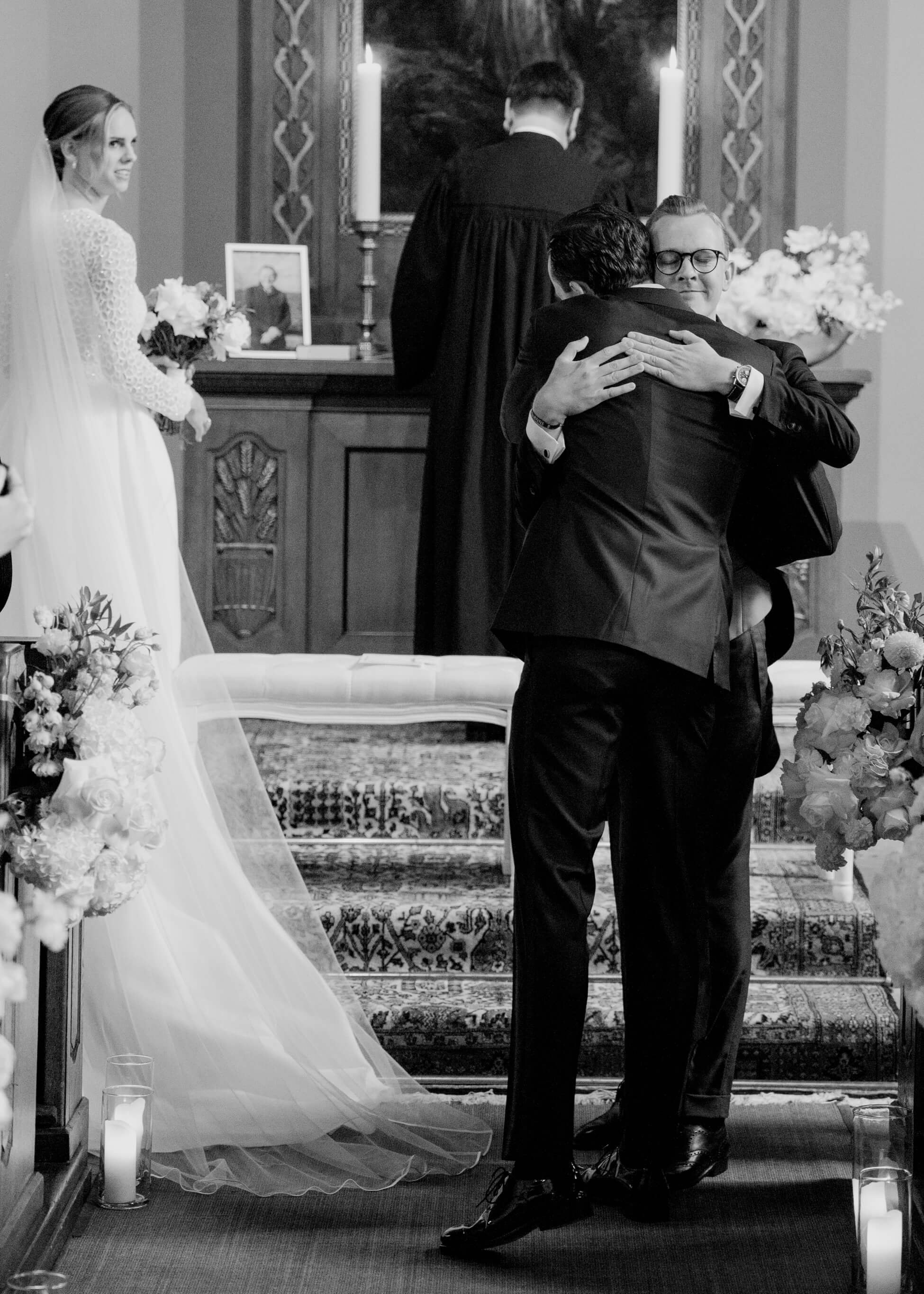 Groom and family in emotional embrace at church altar during ceremony, luxury wedding Frankfurt