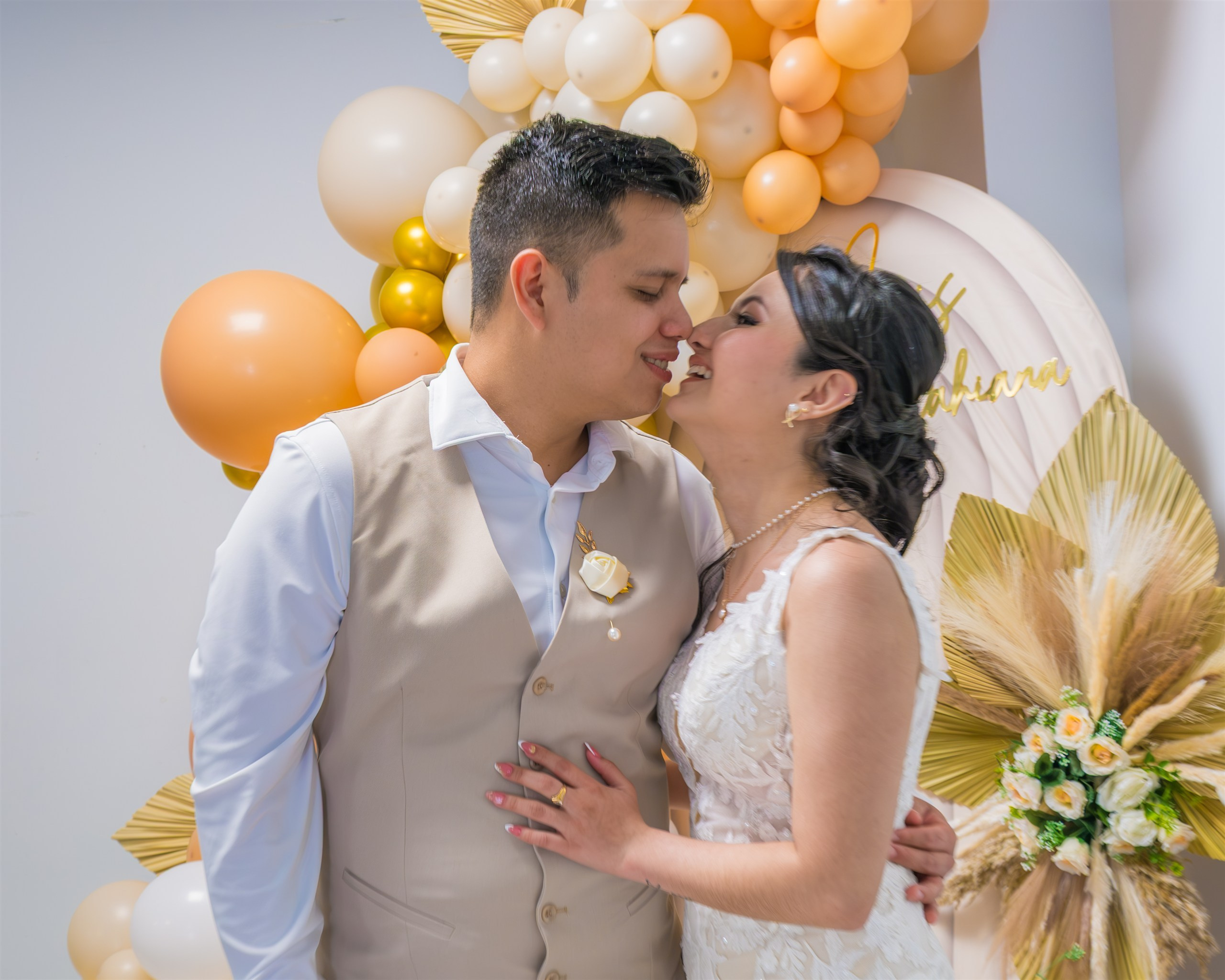 Beso de los novios ante el arco de globos