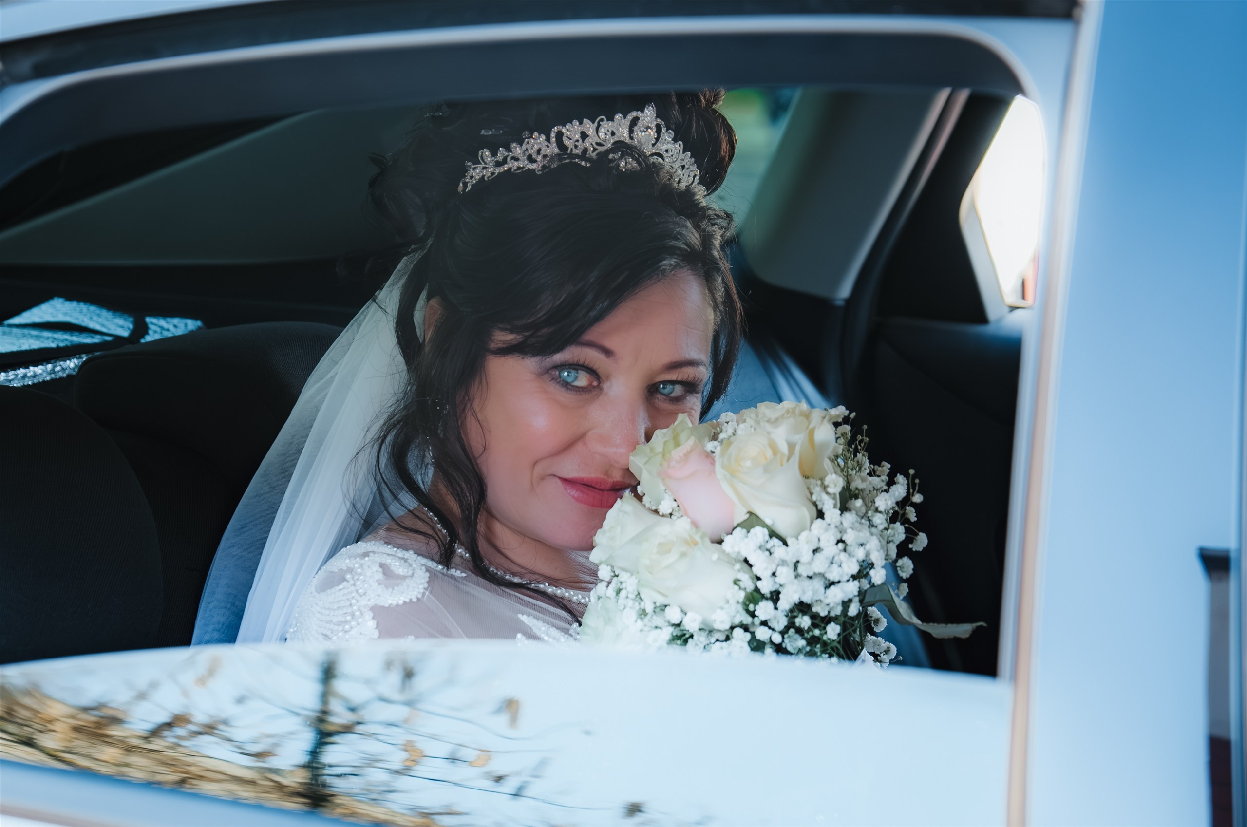 Retrato de Mariana con su ramo a través de la ventanilla del coche