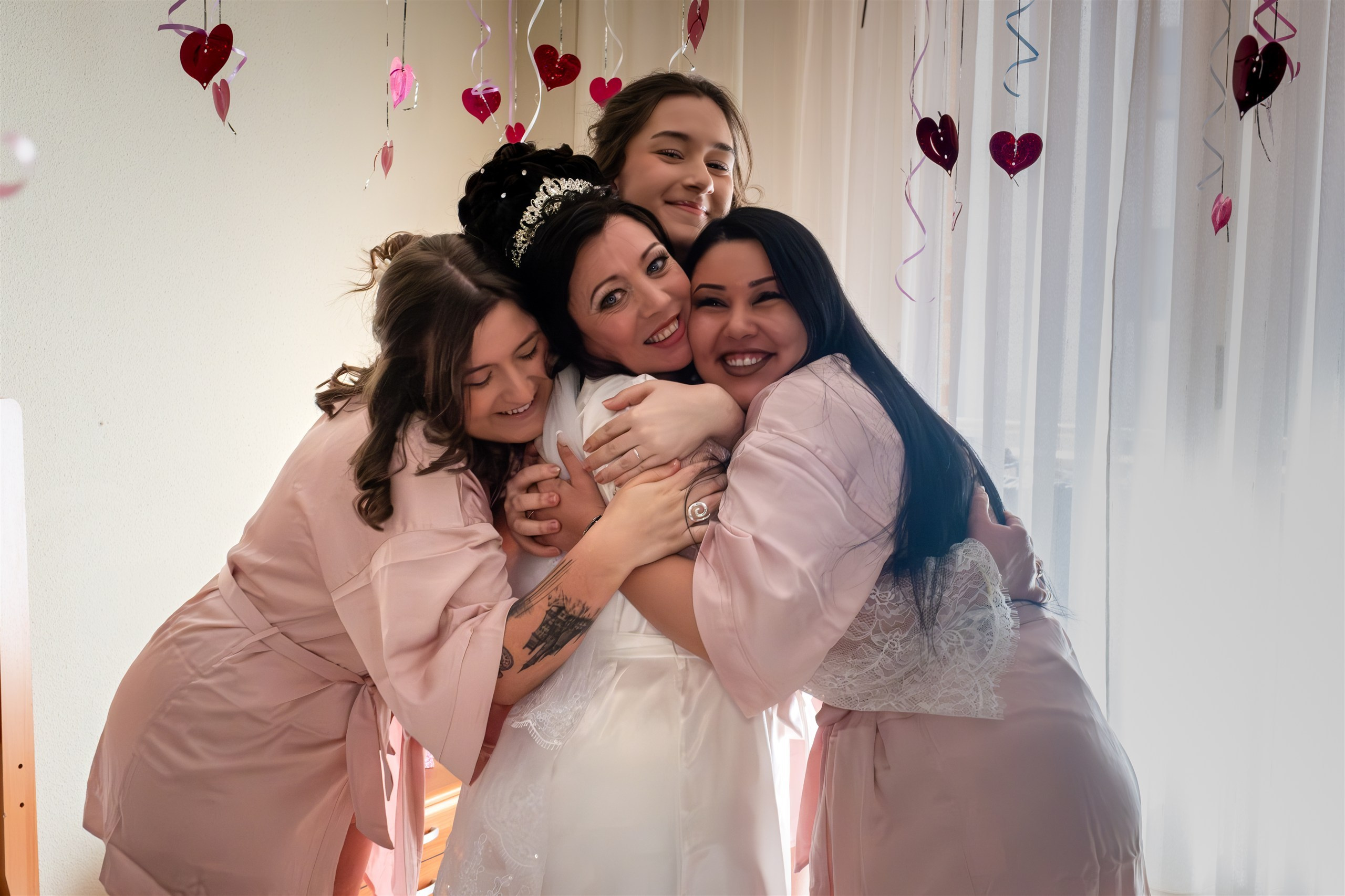 Abrazo de Mariana con sus damas de honor en los preparativos de la boda