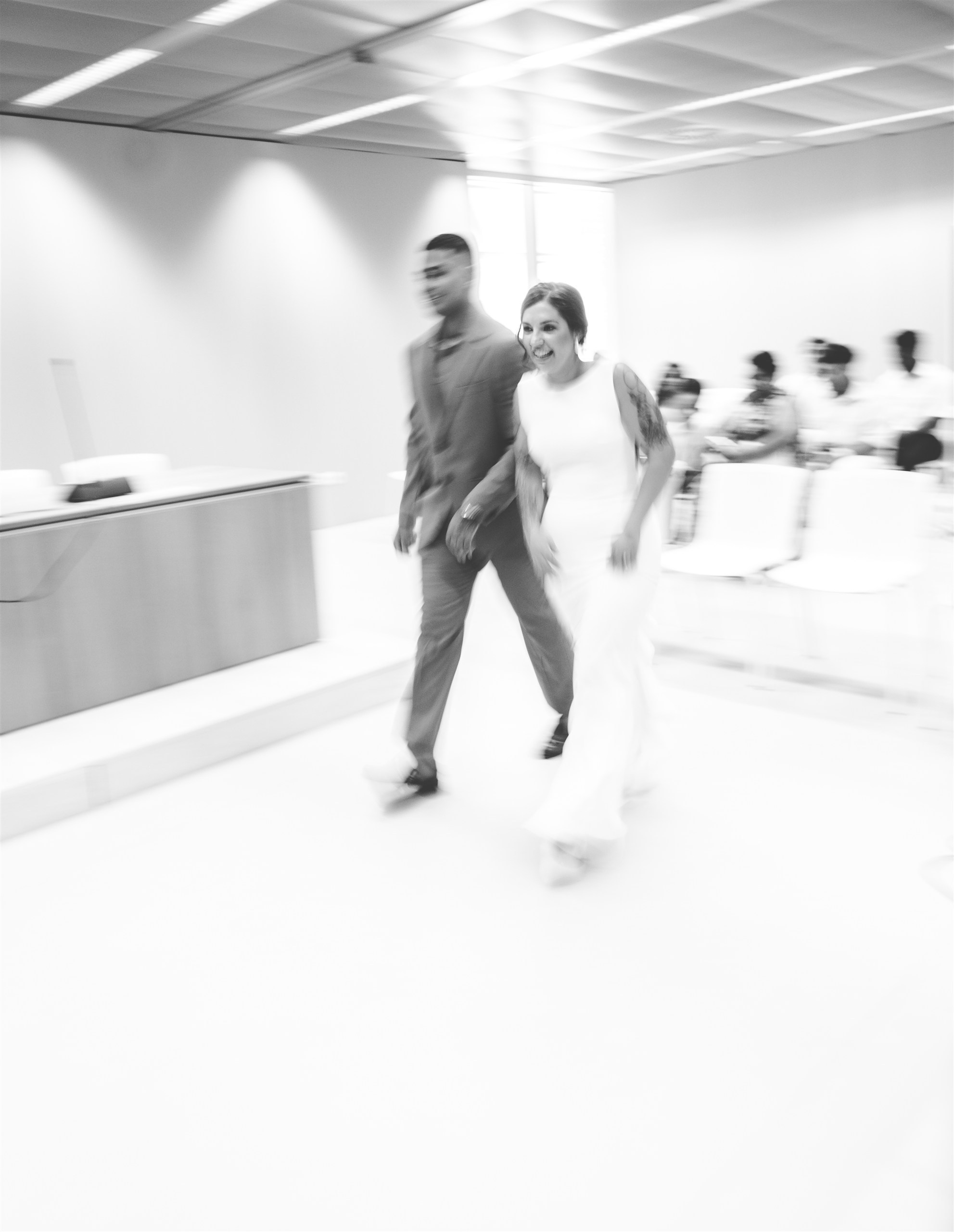 Nora y Luis entrando juntos a la ceremonia, en blanco y negro