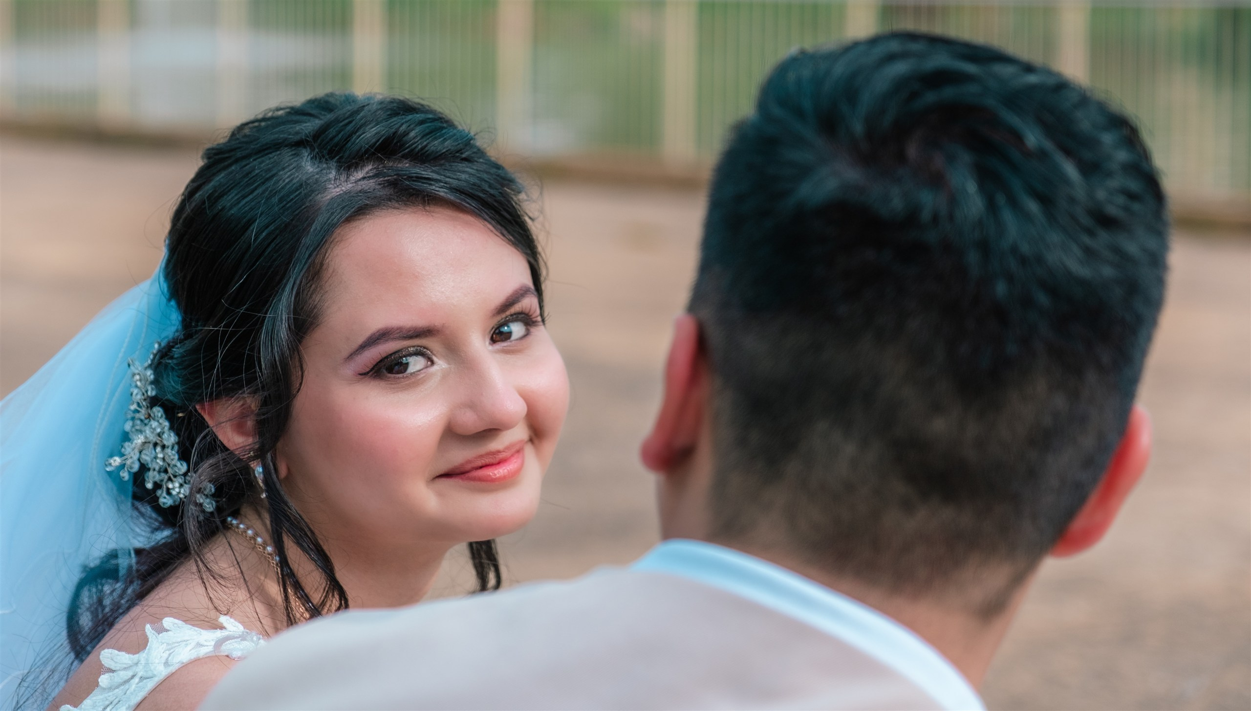 Retrato de la novia mirando a cámara junto al novio