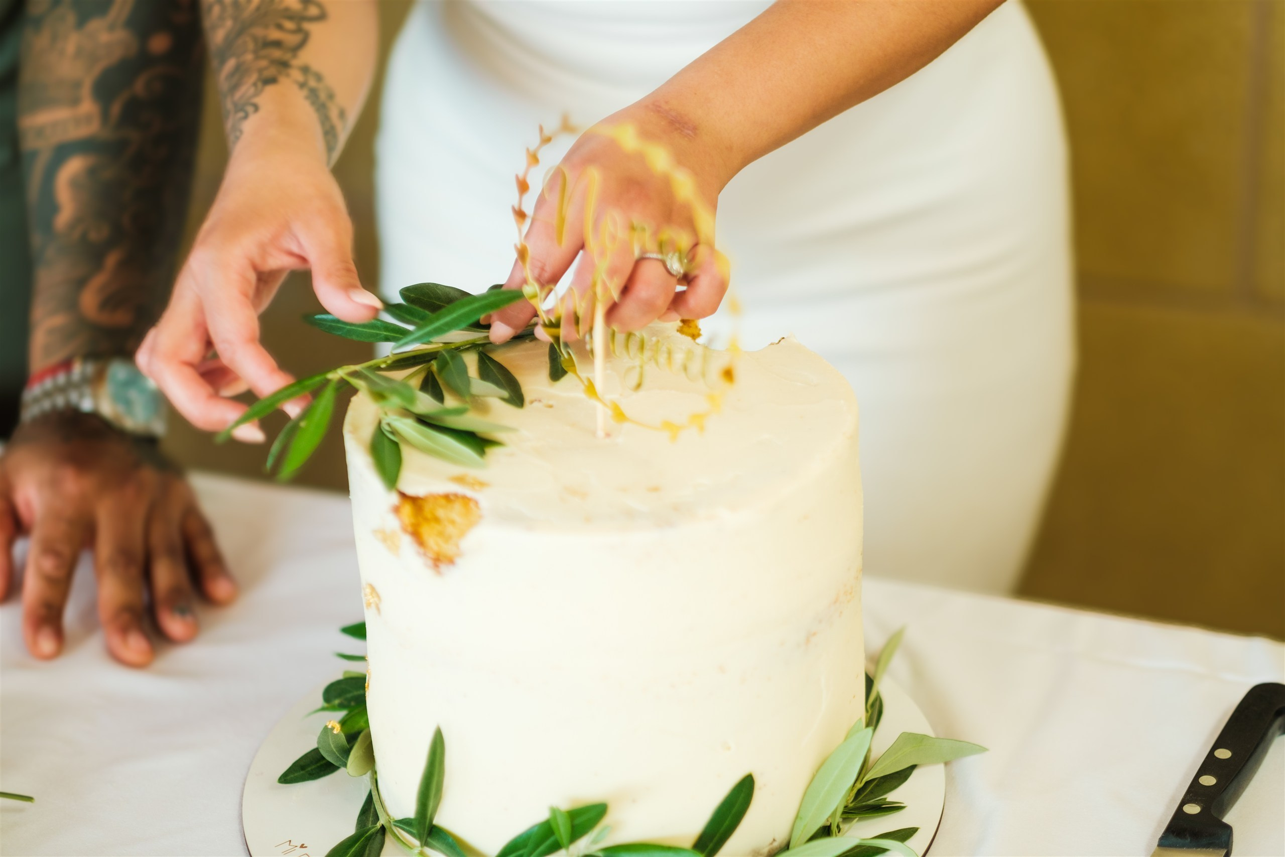 Detalle de la tarta de boda con una rama de olivo