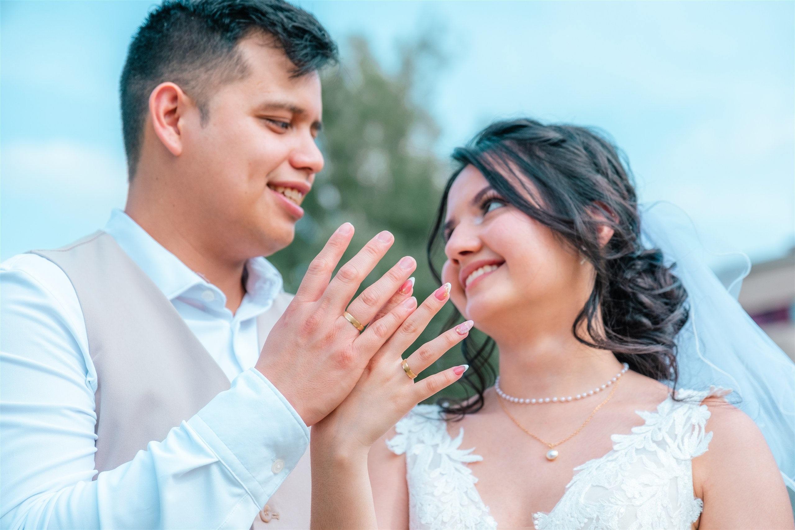 Los novios mirándose mientras muestran las alianzas
