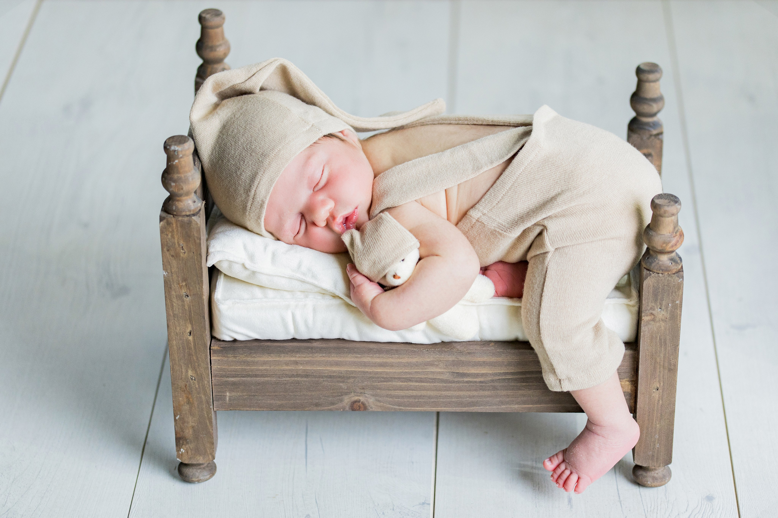 Bebé recién nacido envuelto en técnica wrap de color neutro, reportaje de fotos newborn profesional en Madrid.