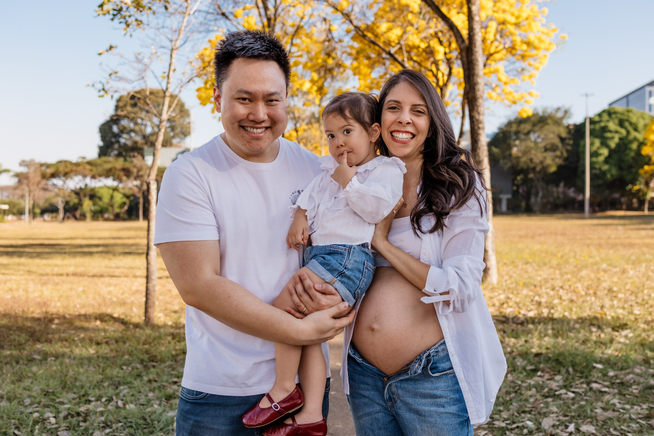 Pai e filha caminhando durante ensaio gestante