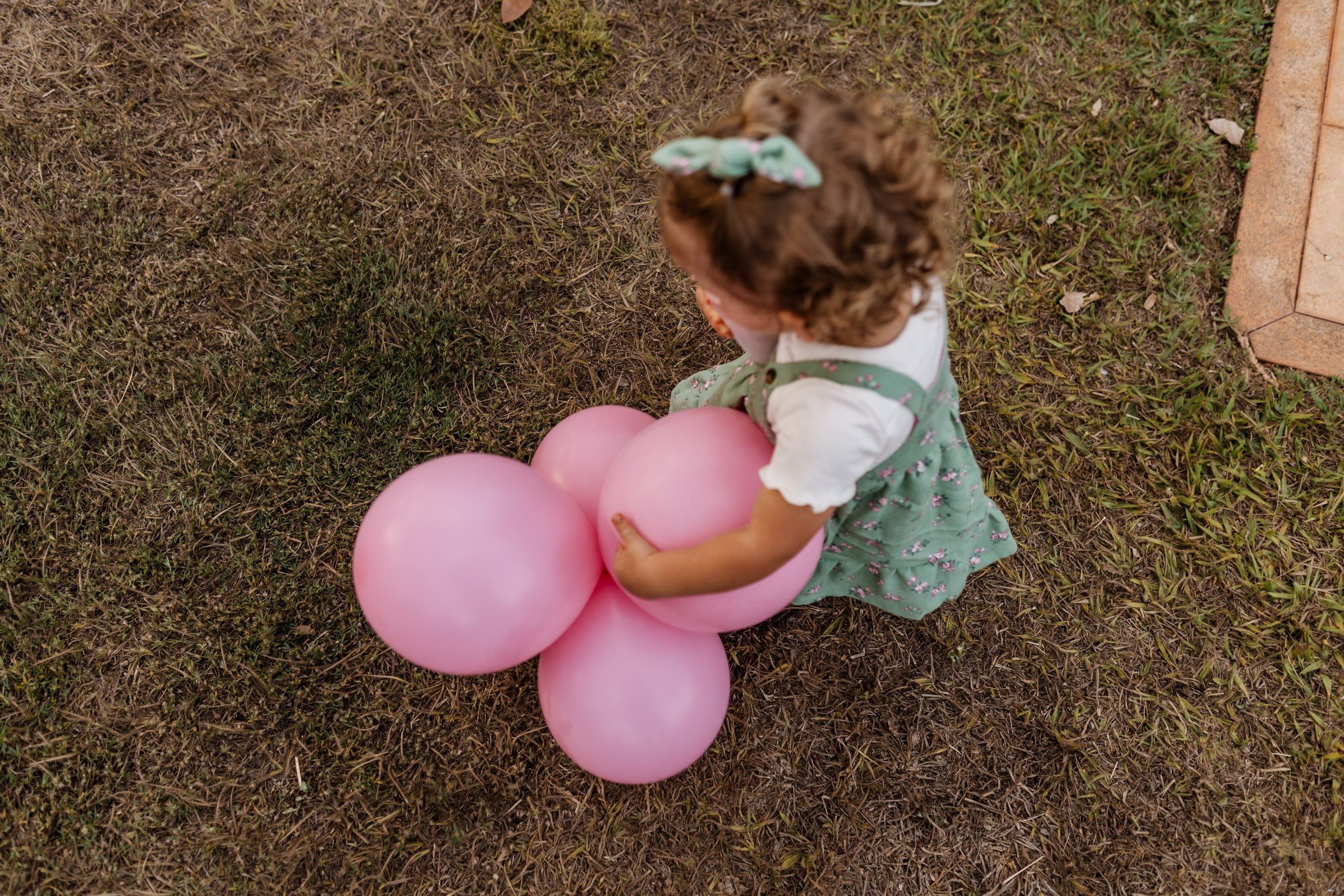 menina carrega balões da festa infantil
