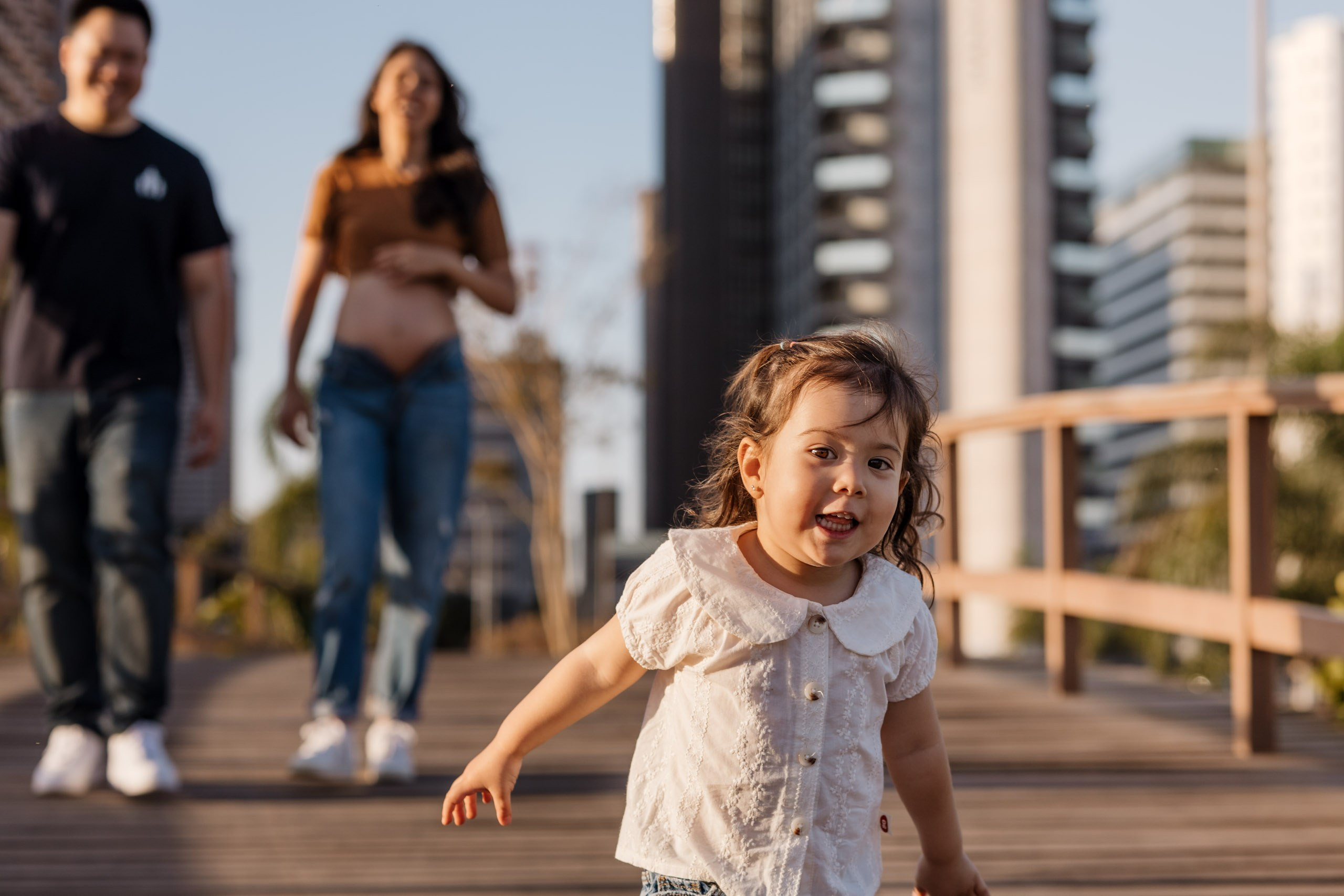 Pais brincam com filha em ensaio externo