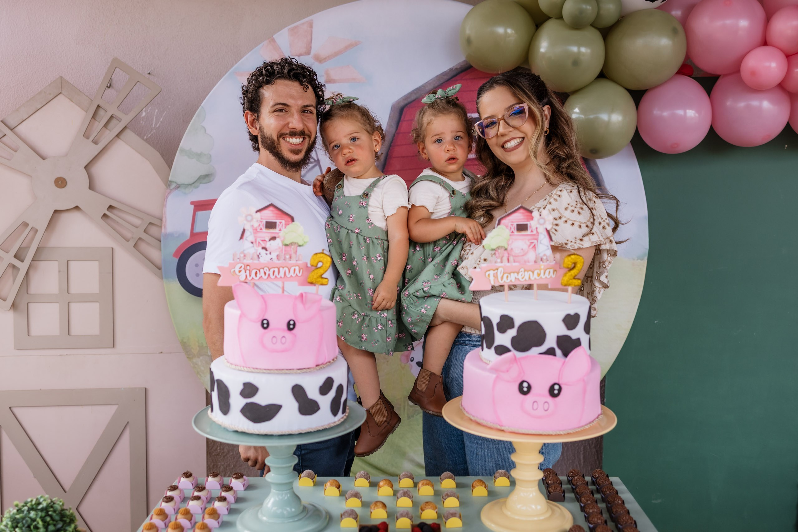 pais com as gêmeas em decoração da festa