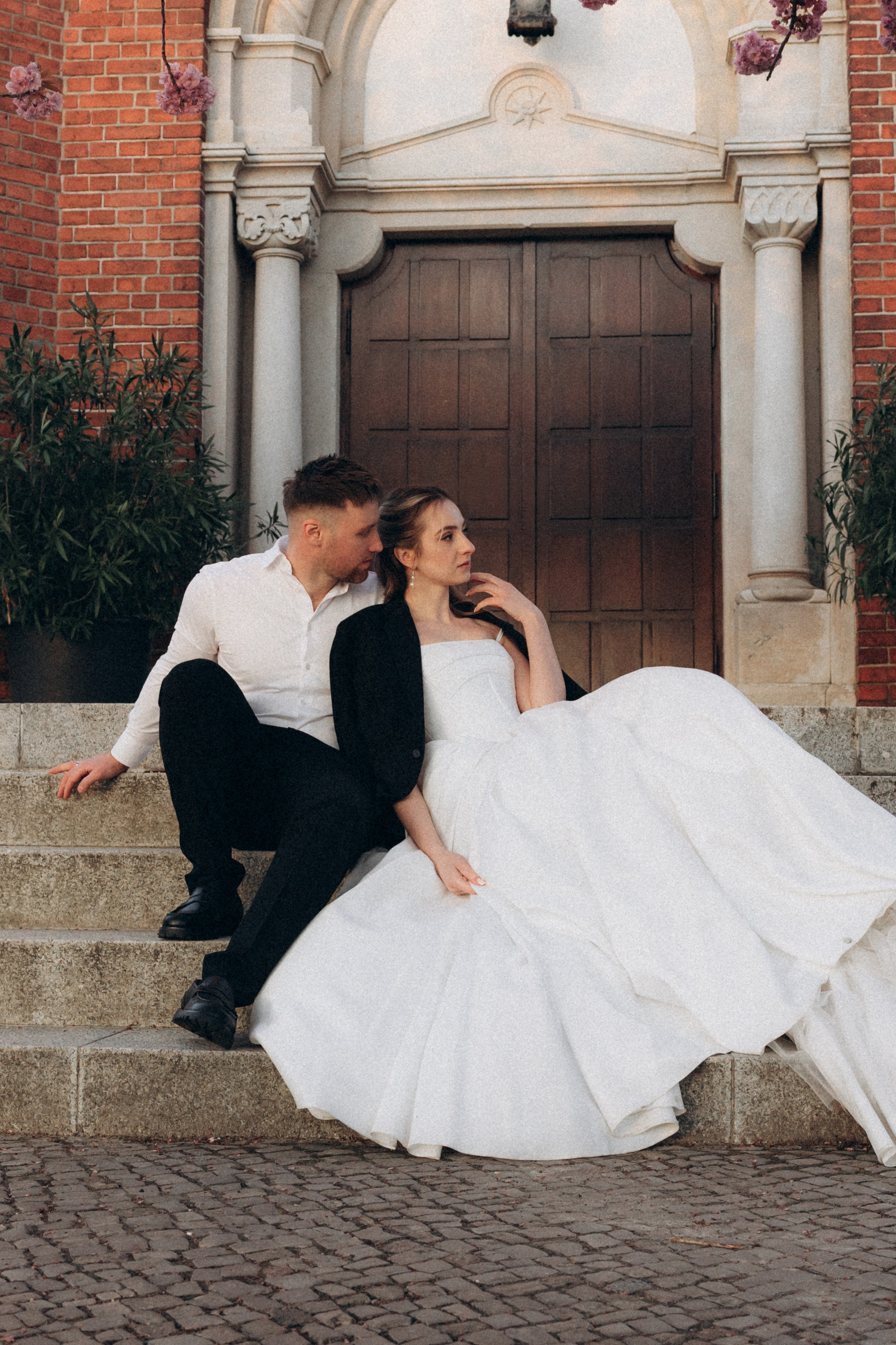 Elegancka para młoda przed zabytkowym wejściem do kościoła