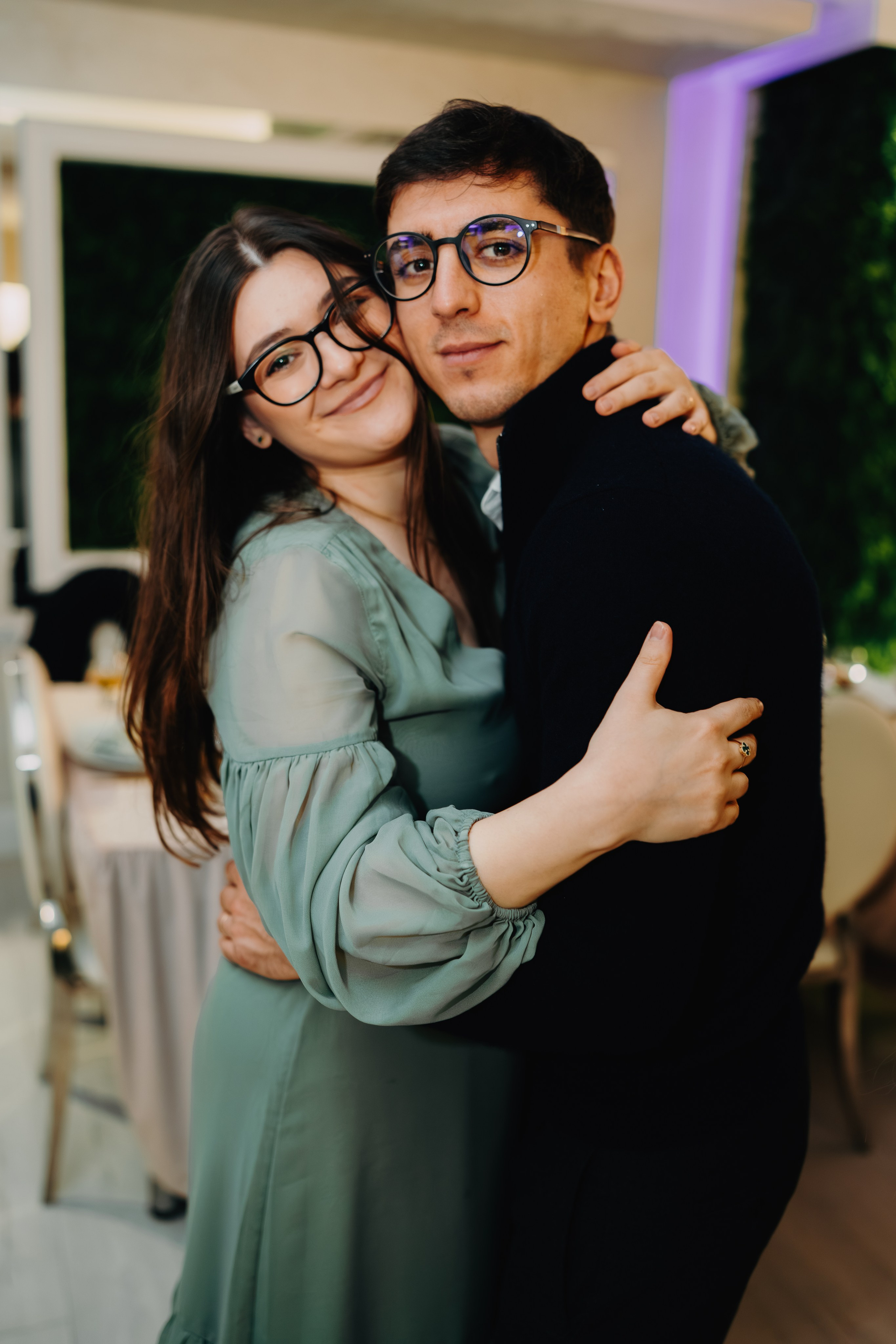 Portret spontan și romantic de la petrecerea de botez a lui Arthur Mihail. Un cuplu de oaspeți dansează sau stă îmbrățișat pe ringul de dans de la Restaurantul Monden din Bârlad, surprins într-un moment personal de bucurie și afecțiune în atmosfera festivă.