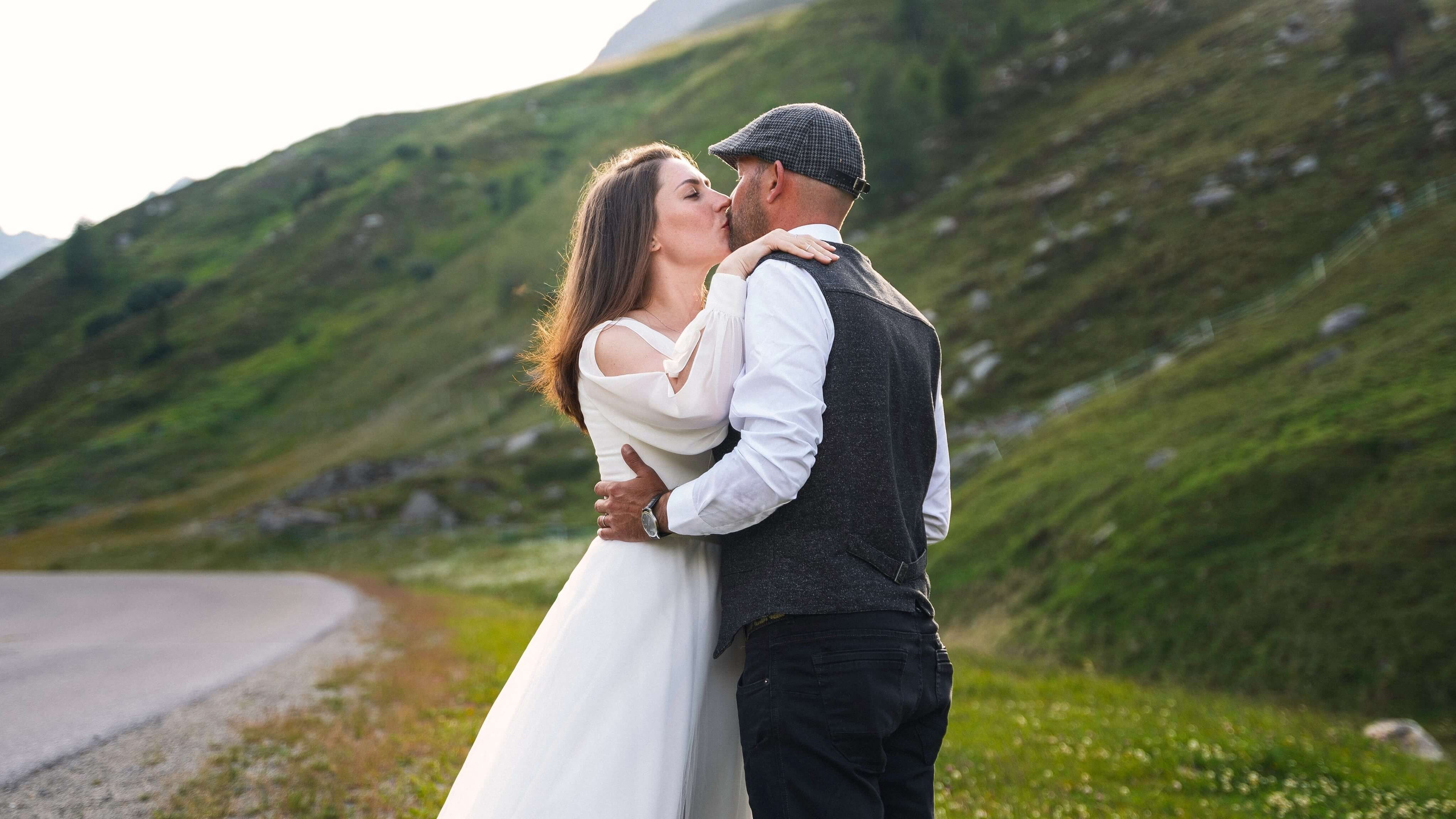 Hochzeitsfotografie in Sölden: Kuss des Brautpaares auf einer Almwiese in den Alpen.